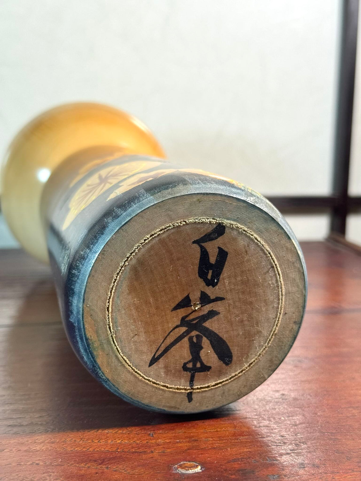 kokeshi, poupée japonaise en bois de Usuki Hakuho bleue avec motif branche de prunier en fleur, la signature de l'artisan au dessous