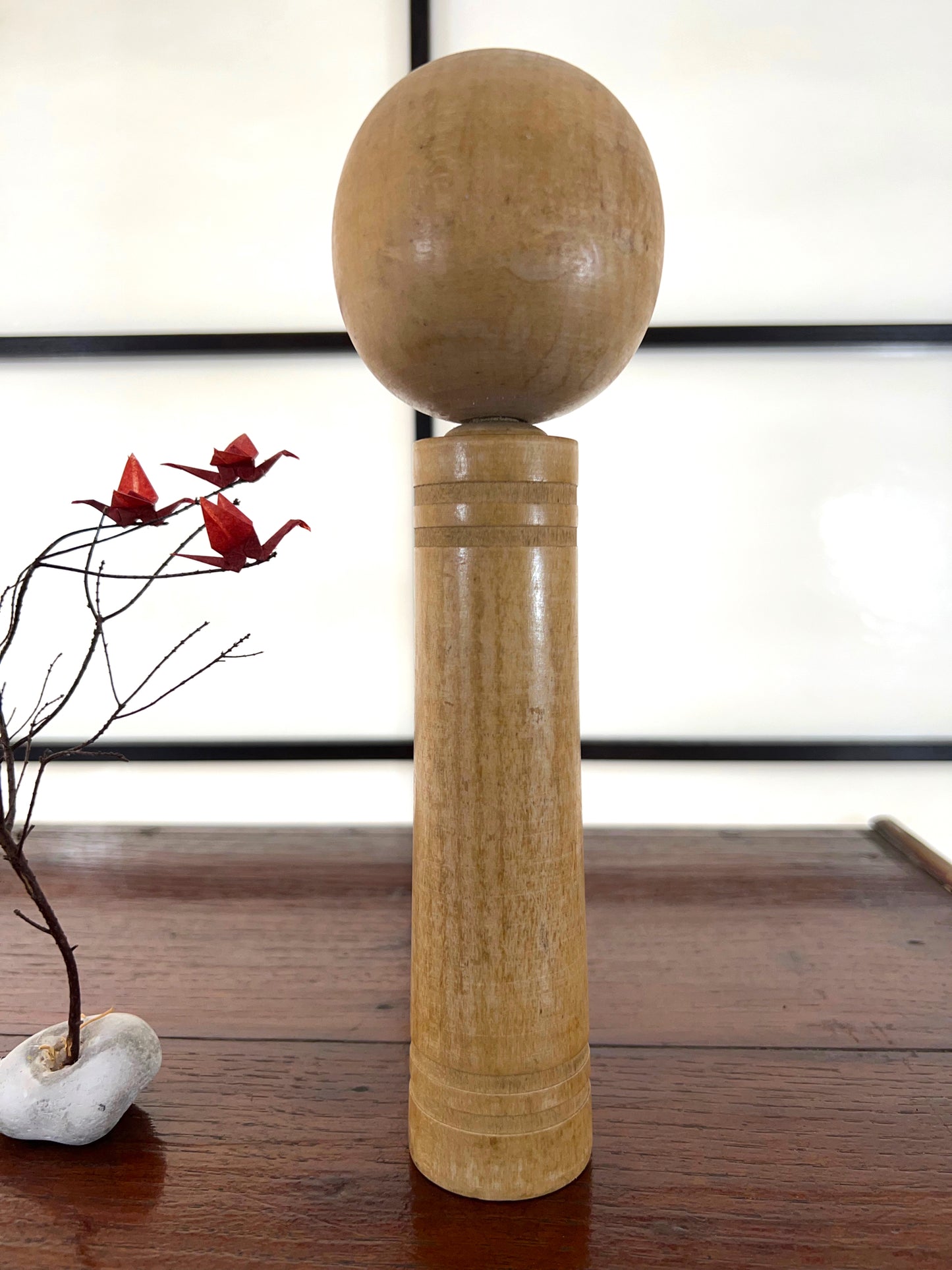 kokeshi poupée japonaise en bois gravé d'une visage de démon sur le corps, vu de dos