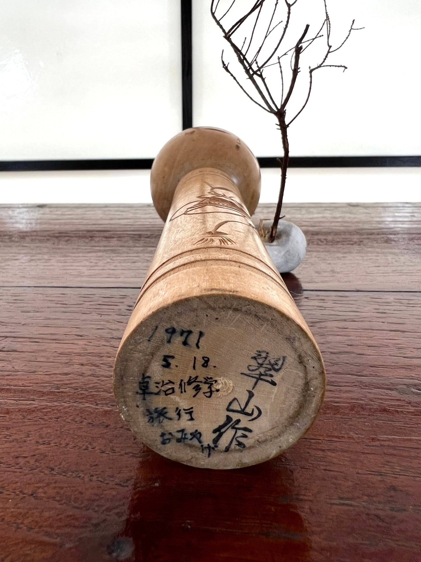 kokeshi poupée japonaise en bois gravé d'une visage de démon sur le corps, signature de l'artisan