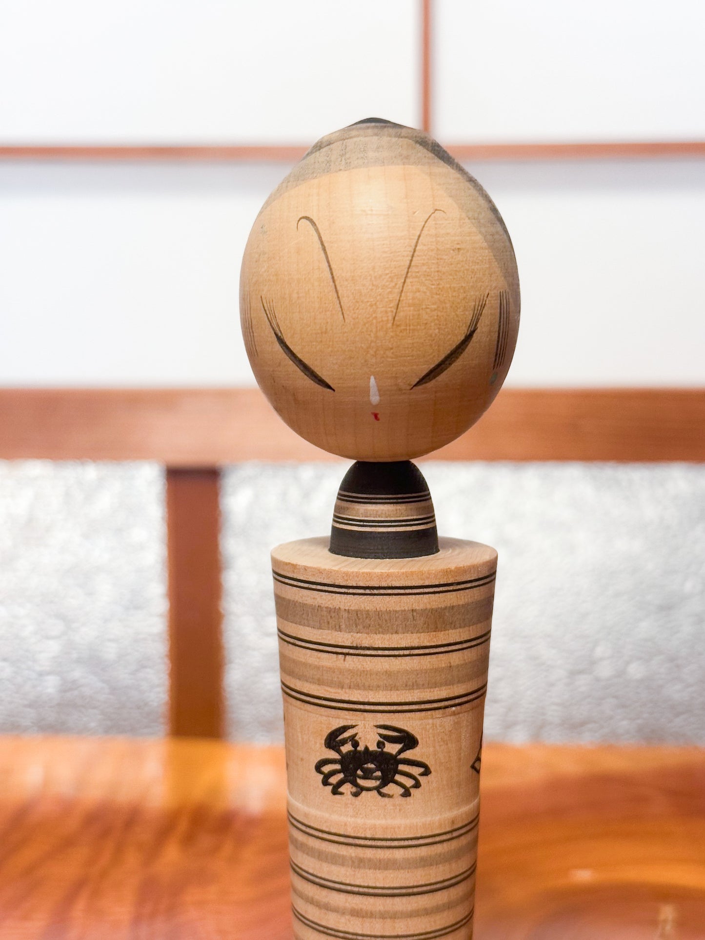 kokeshi sumi-e de Hatsutaro rayé avec motif crabe et coquillages, gros plan sur le buste