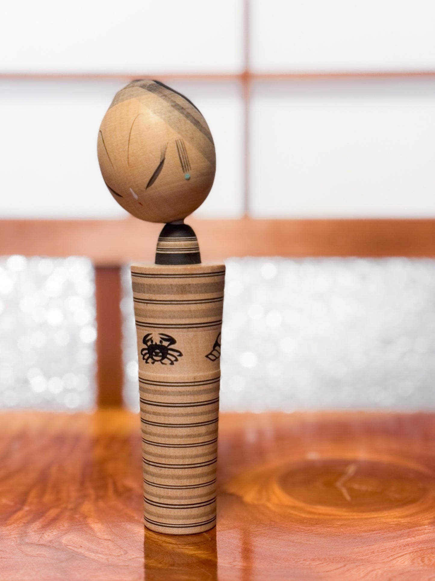 kokeshi sumi-e de Hatsutaro rayé avec motif crabe et coquillages, vu de 3/4