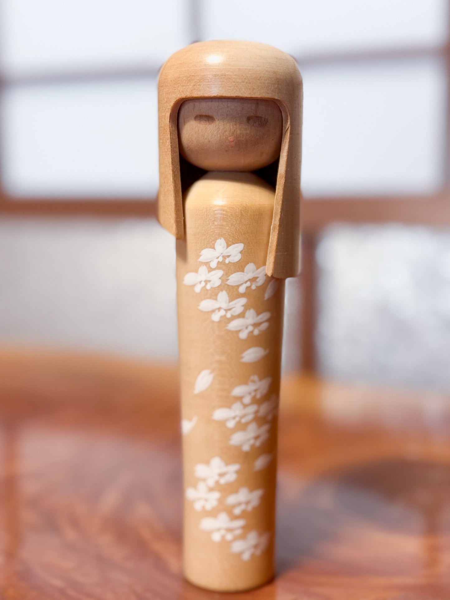 kokeshi de Miyashita Mihutsu en bois naturel avec fleurs blanches peintes et longue chevelure, face