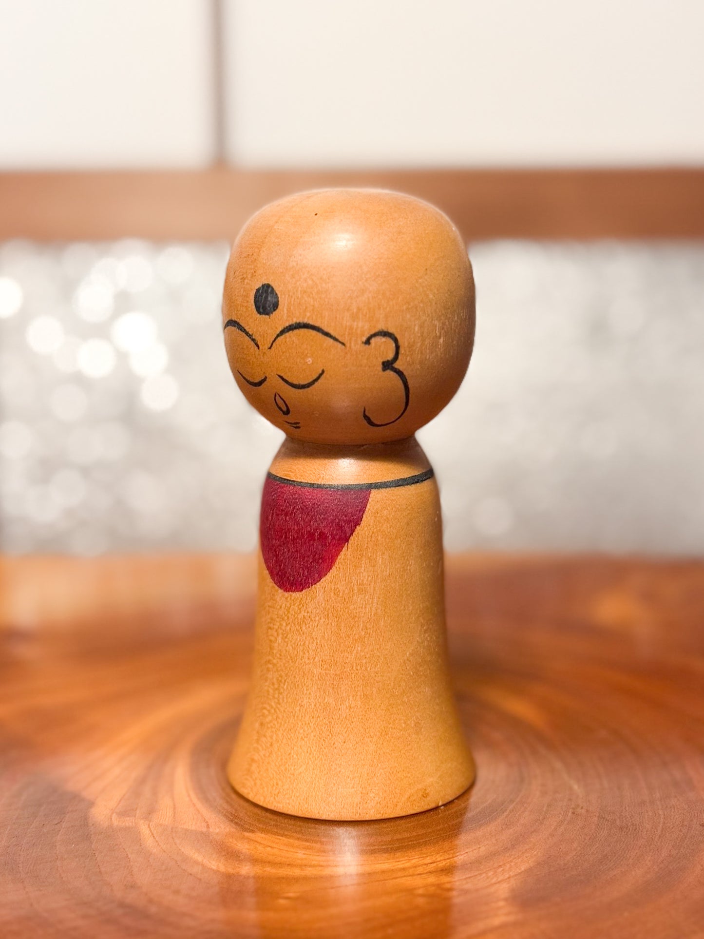 kokeshi de Asakusa Koyo représentant un jizo avec bavoir rouge, profil gauche