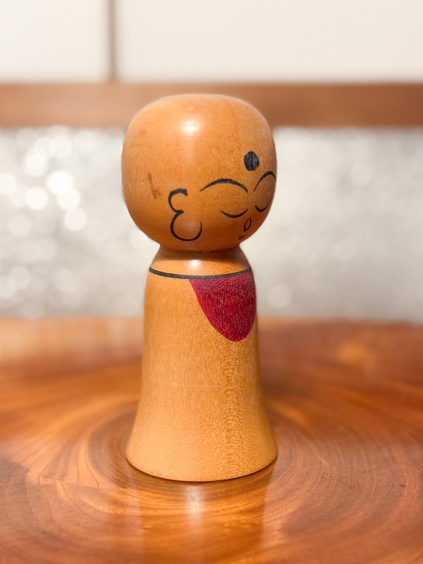 kokeshi de Asakusa Koyo représentant un jizo avec bavoir rouge, profil droit