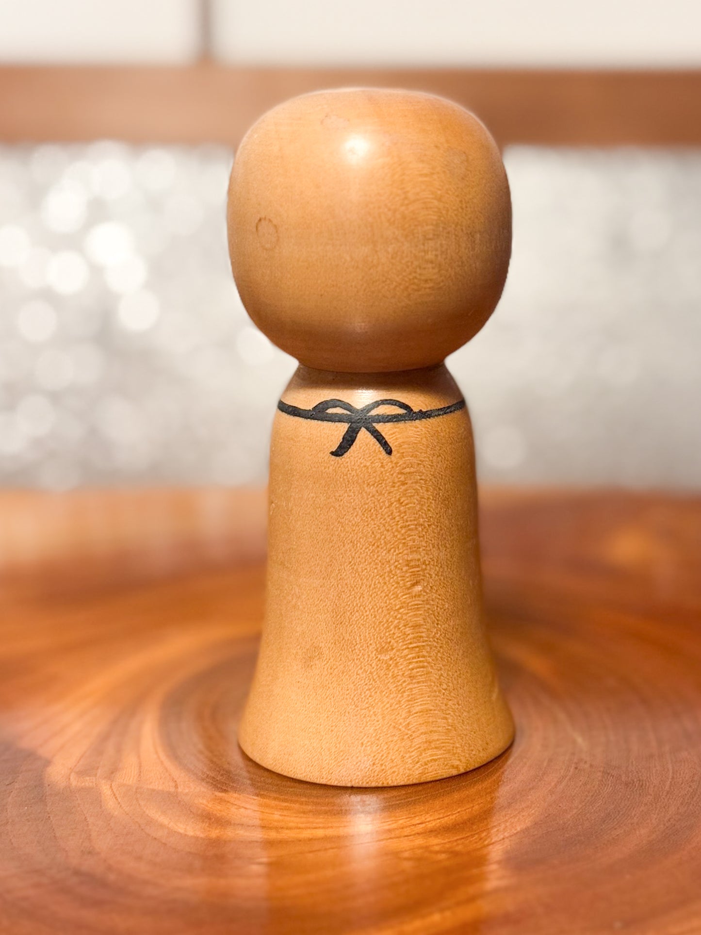 kokeshi de Asakusa Koyo représentant un jizo avec bavoir rouge, vu de dos