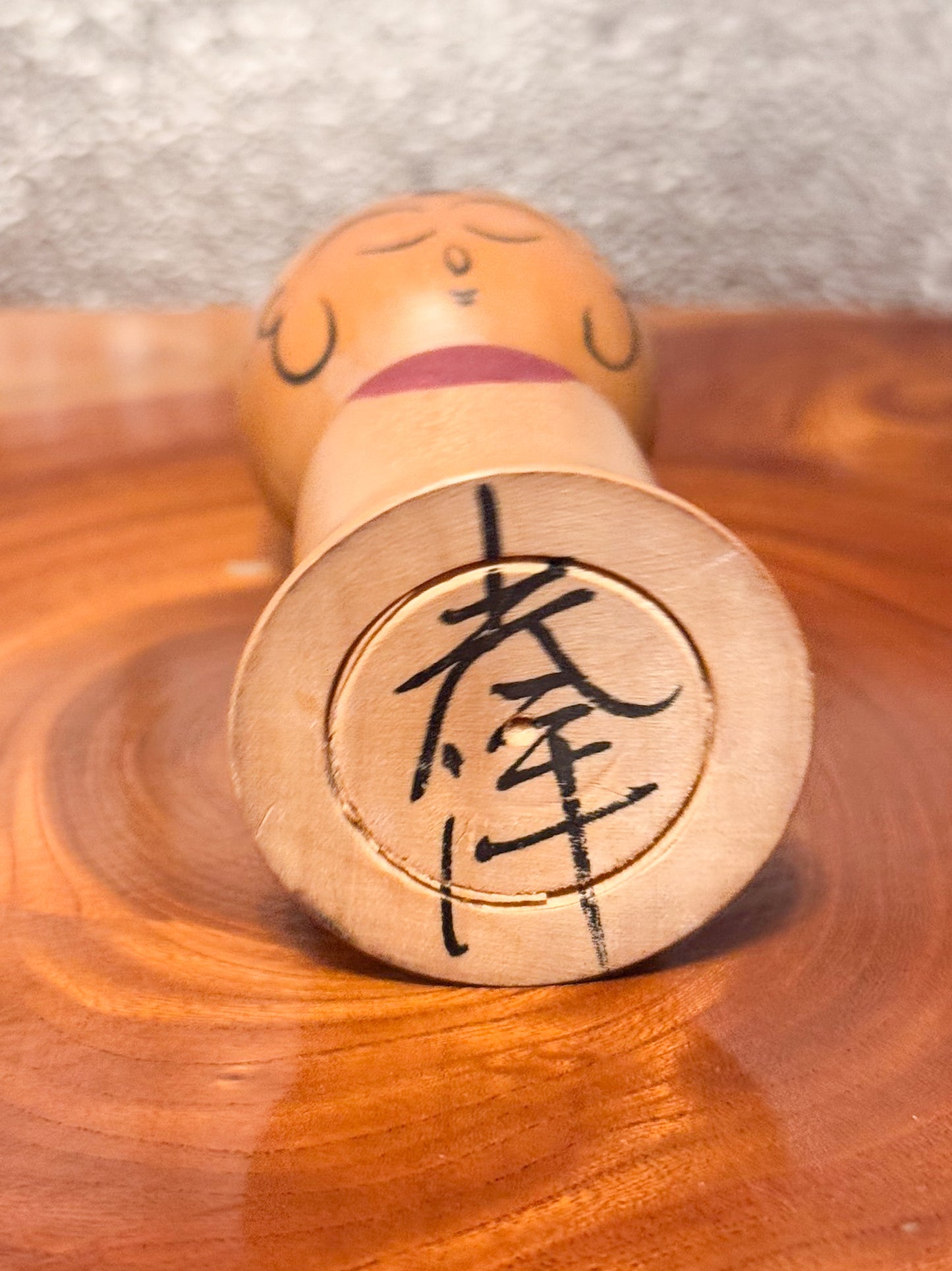 kokeshi de Asakusa Koyo représentant un jizo avec bavoir rouge, le dessous avec la signature de l'artisan