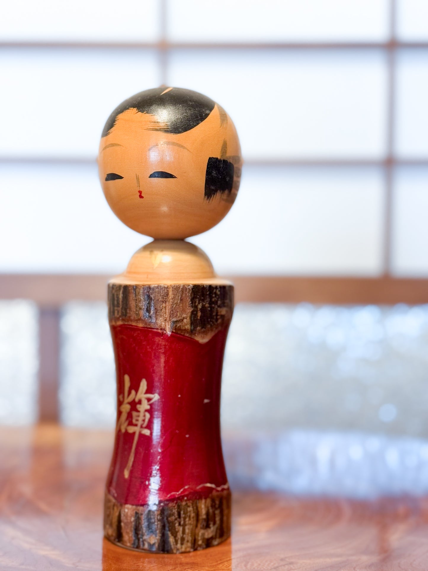Kokeshi en bois brut avec laque rouge et kanji "zen" doré
