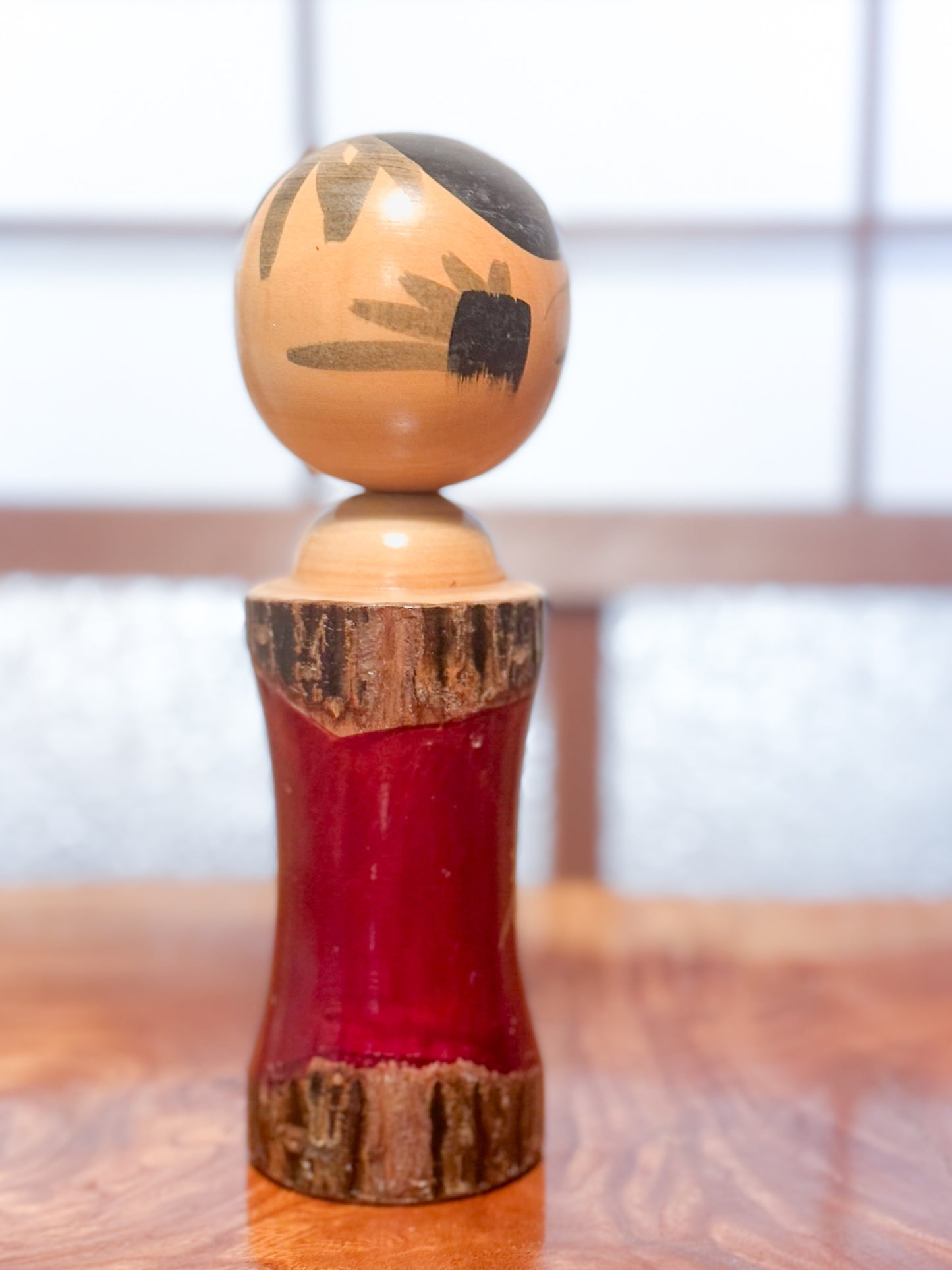 Kokeshi en bois brut avec laque rouge et kanji "zen" doré, profil droit