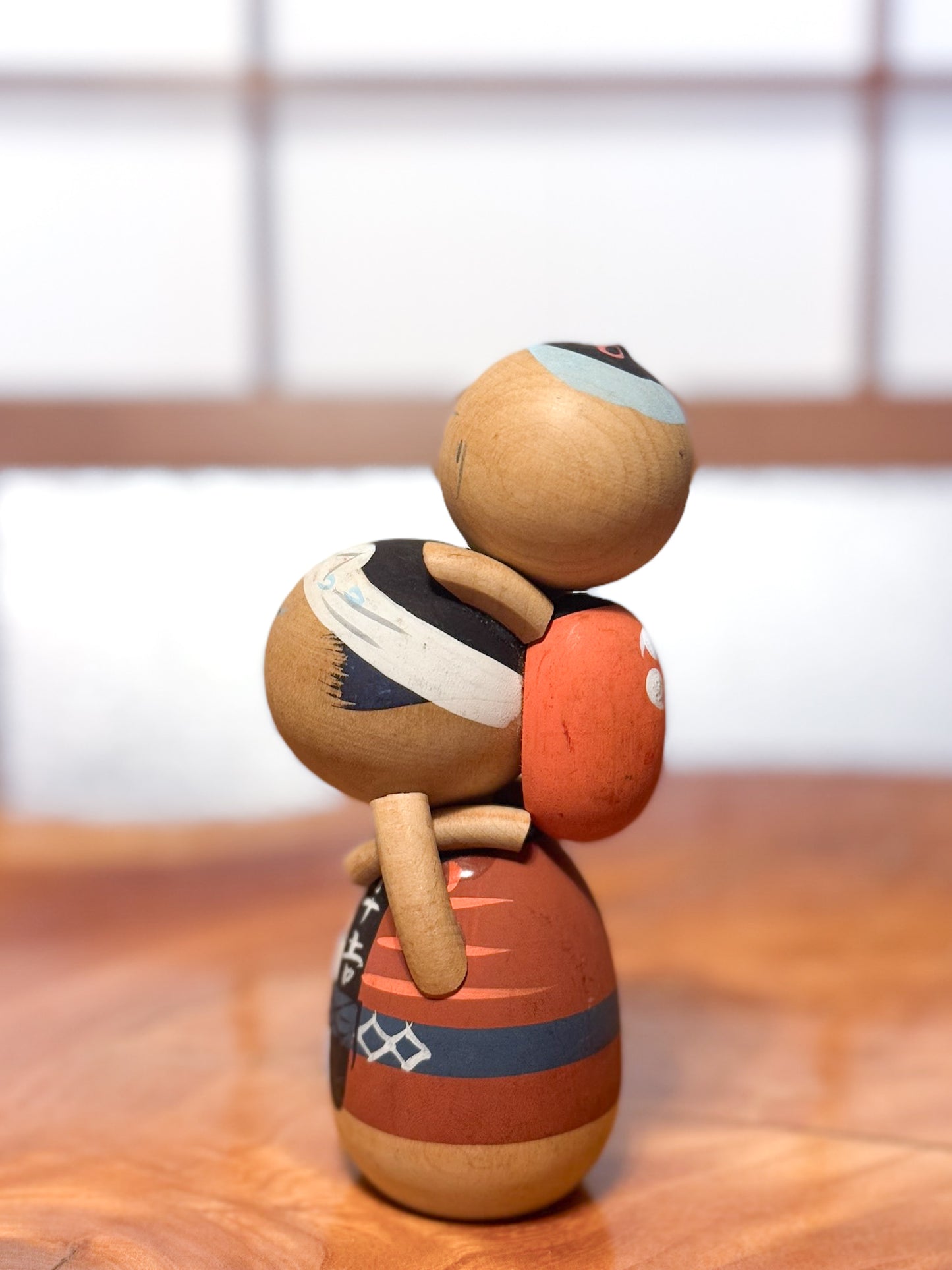 kokeshi japonaise vintage père portant enfant sur les épaules, profil gauche