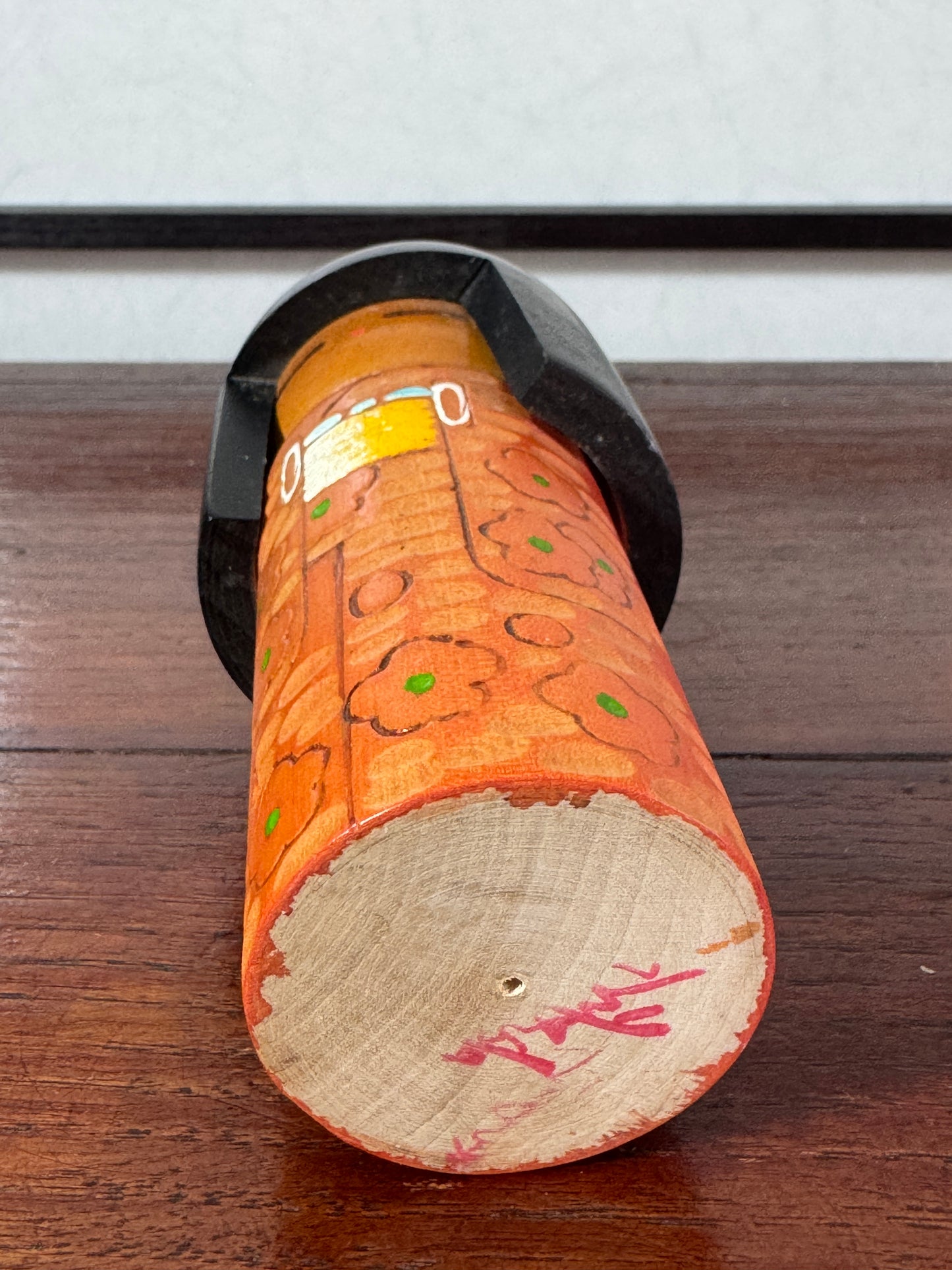 kokeshi créative vintage de Kisaku au kimono gravé et pyrogravé à fleurs, vu du dessous la signature de l'artisan