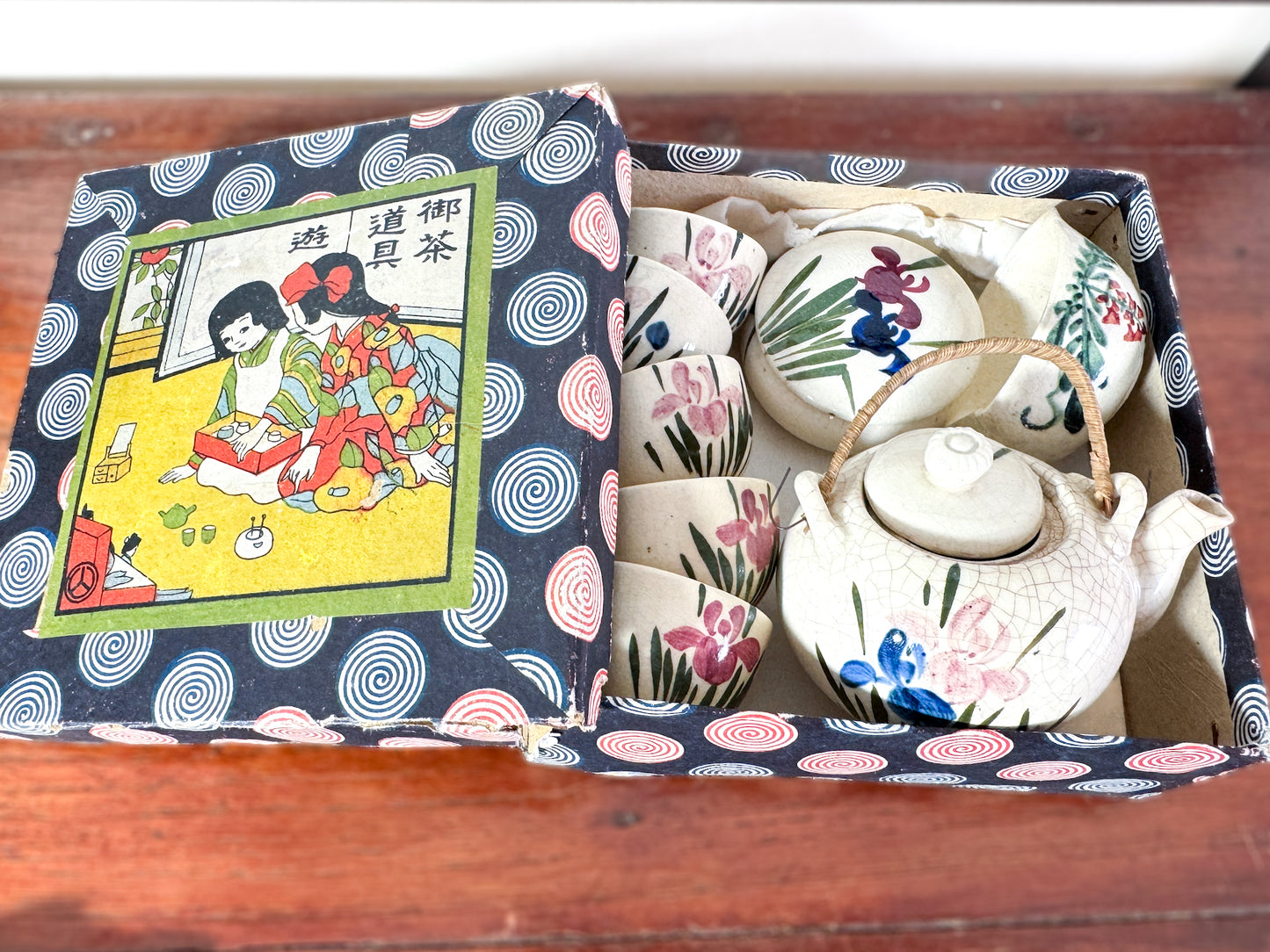 Service à thé miniature japonais vintage avec motifs d’iris, boîte imprimée spirales et scène de cérémonie du thé, boite couvercle ouvert