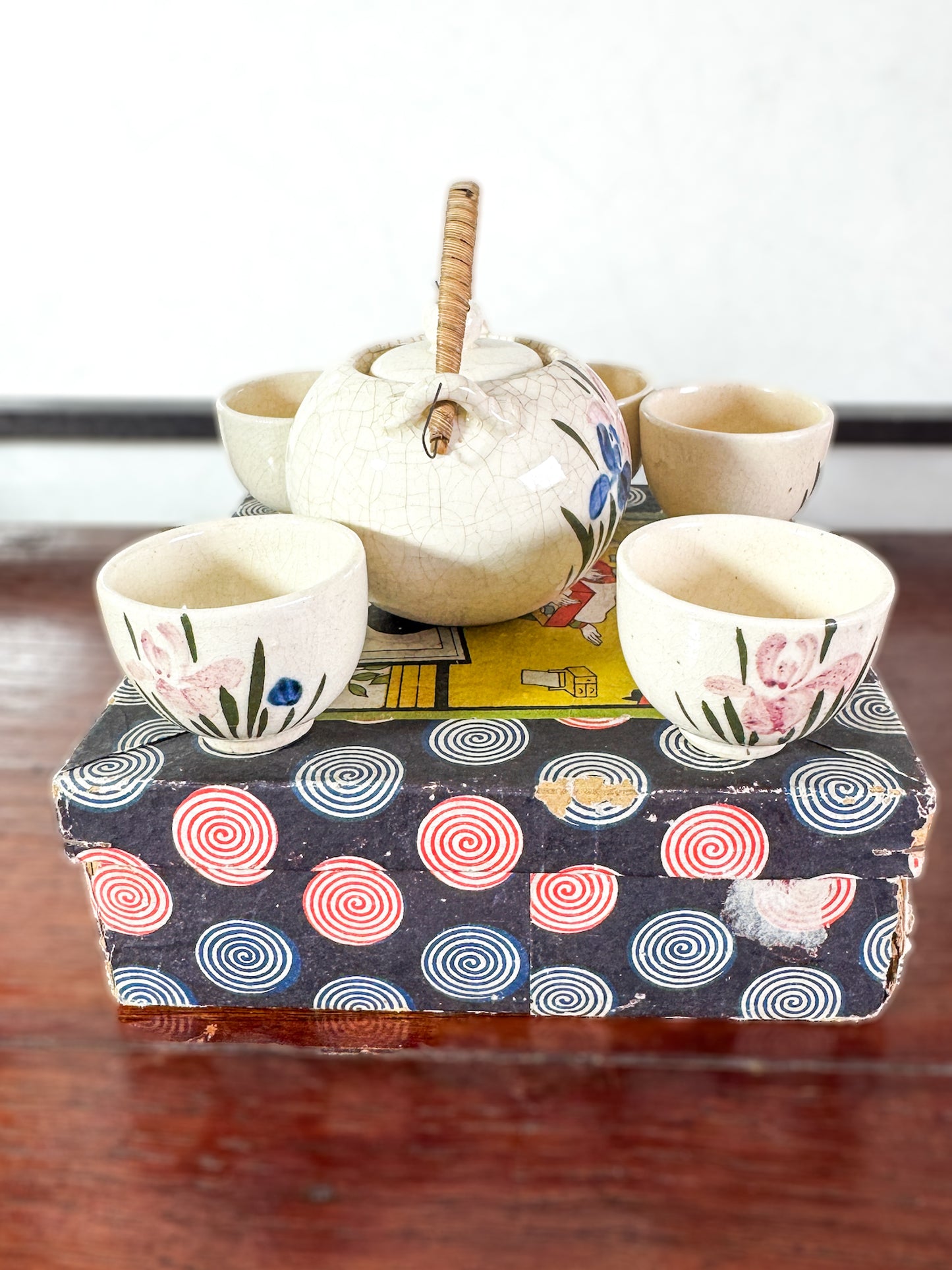 Service à thé miniature japonais vintage avec motifs d’iris, boîte imprimée spirales et scène de cérémonie du thé, vu profil gauche