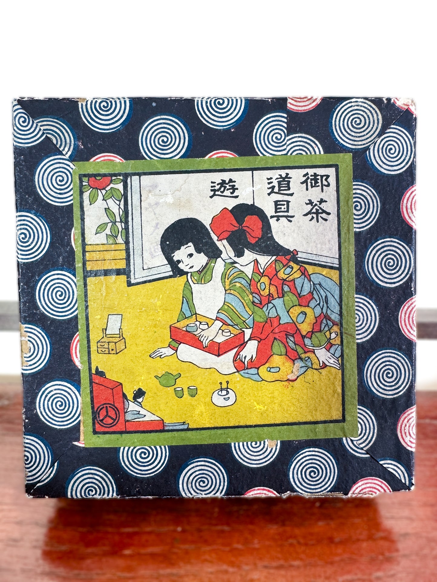 Service à thé miniature japonais vintage avec motifs d’iris, gros plan sur la boîte imprimée spirales et scène de cérémonie du thé