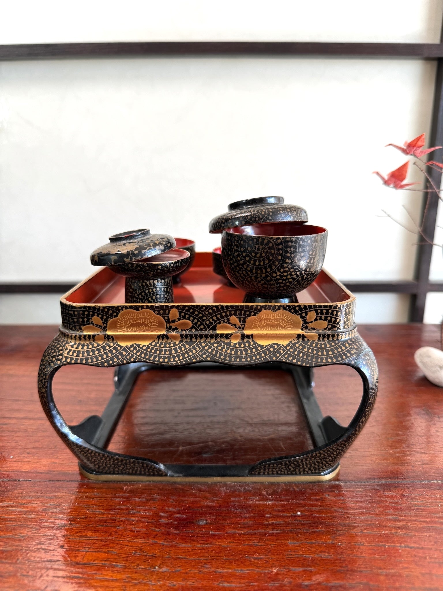 Ensemble miniature japonais comprenant un plateau en laque noire et rouge avec décor doré et plusieurs petits bols et coupes assortis, les pots couvercle ouvert