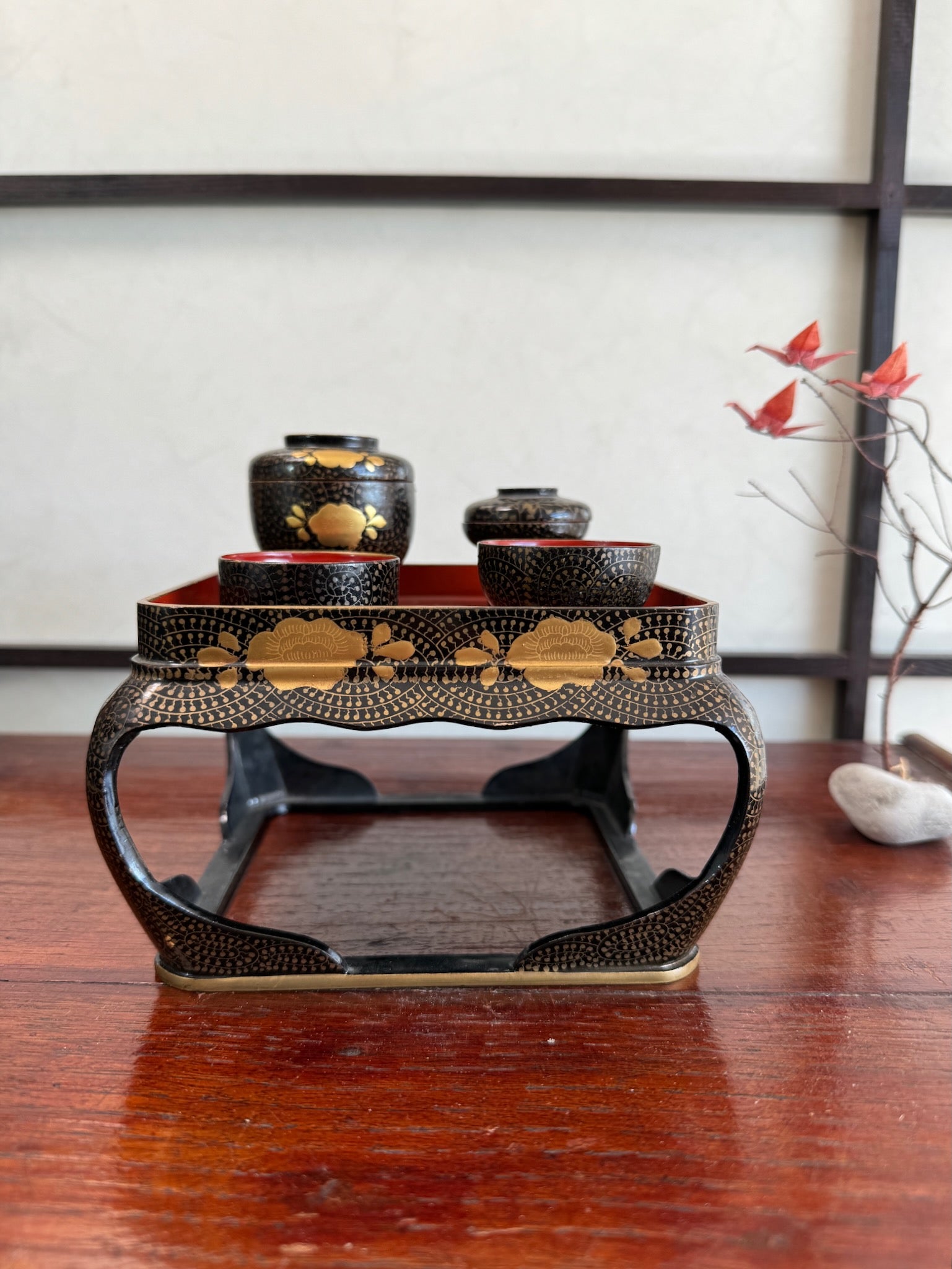Ensemble miniature japonais comprenant un plateau en laque noire et rouge avec décor doré et plusieurs petits bols et coupes assortis, motif fleurs dorées