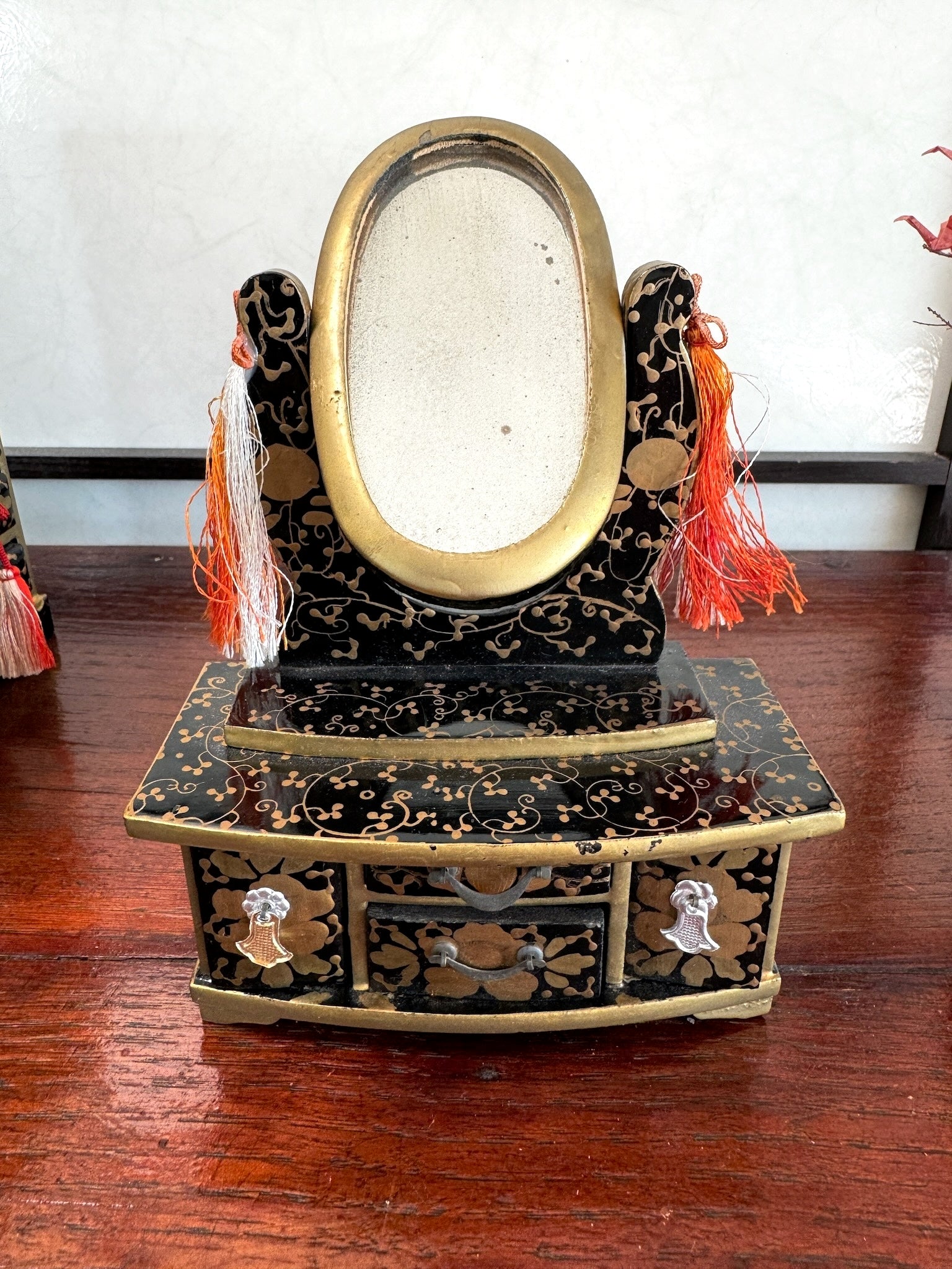 coiffeuse miniature en laque noire motif doré avec miroir ovale pivotant, tiroirs fermés