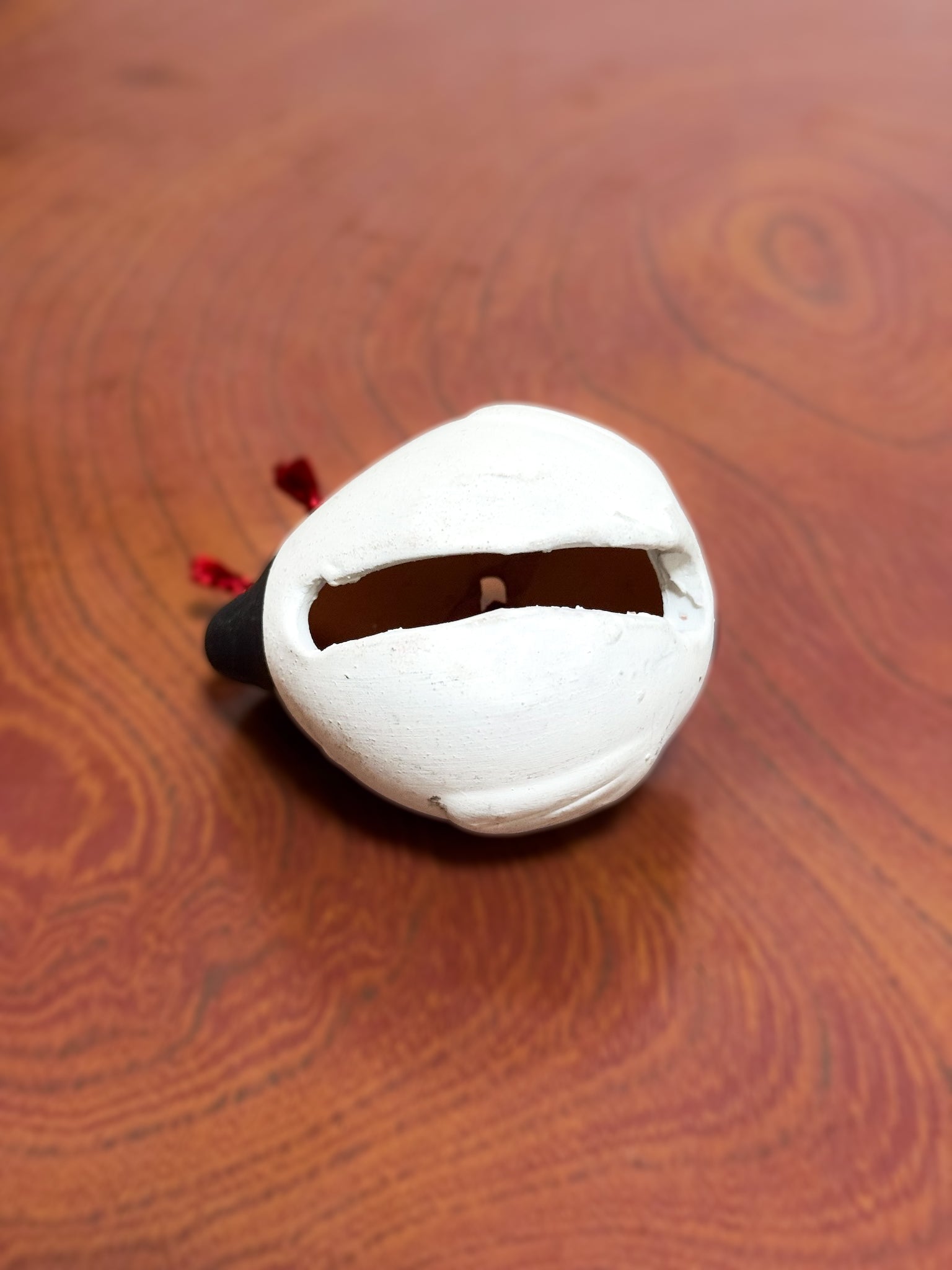 Clochette japonaise en céramique en forme de fugu noir et blanc avec cordelette rouge, vu de dessous