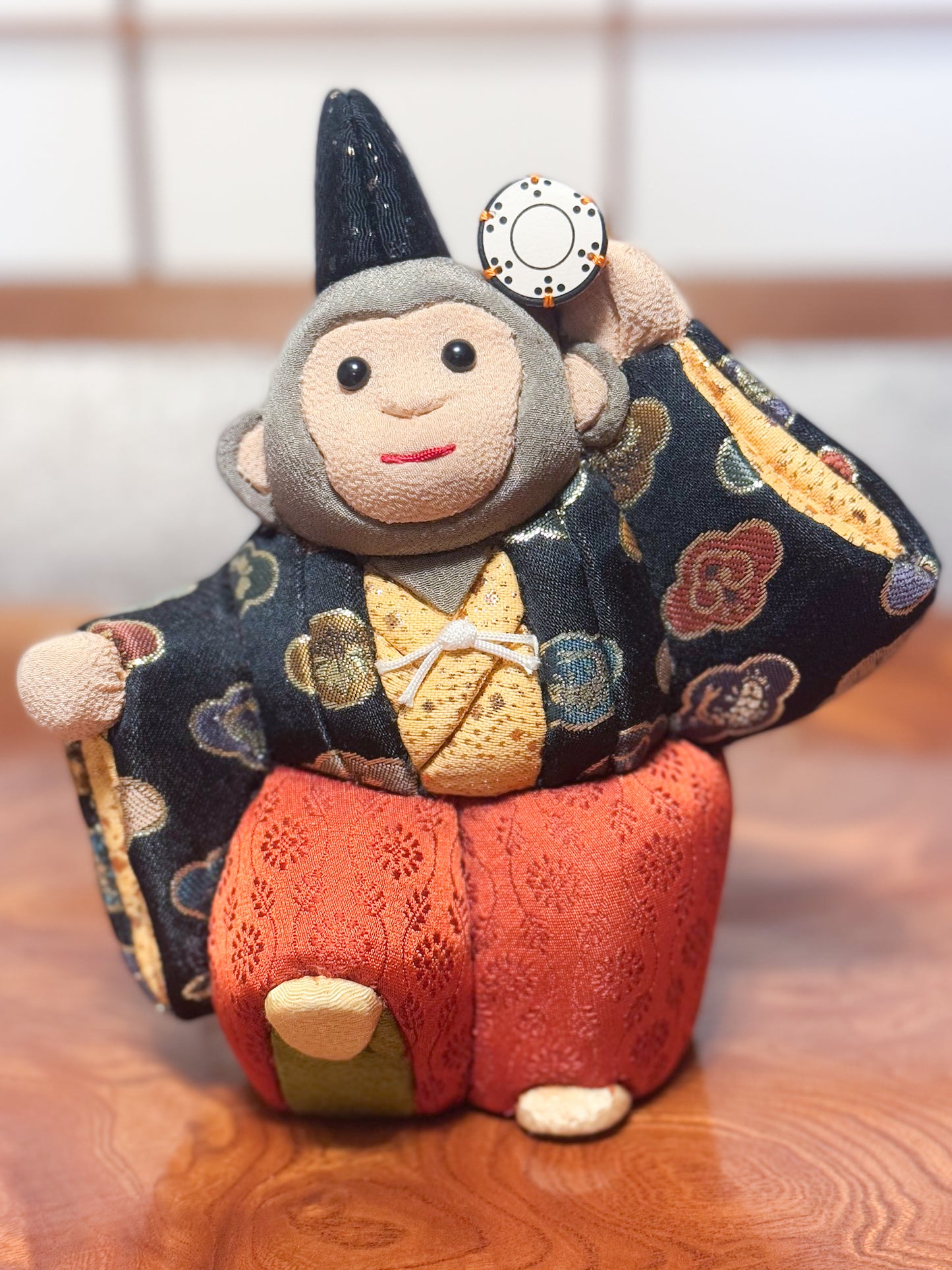 poupée japonaise kimeomi représentant un singe en habits traditionnels et portant un petit tambour