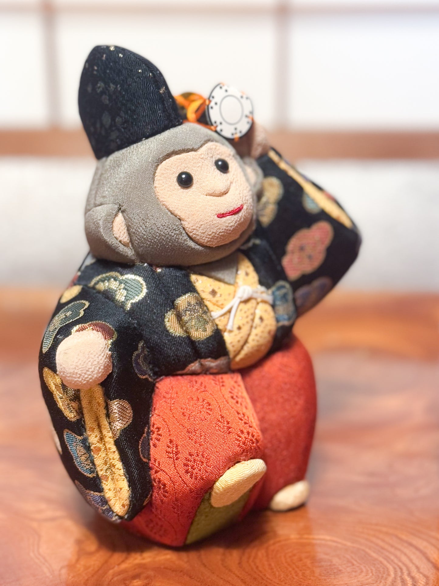 poupée japonaise kimekomi représentant un singe en habits traditionnels et portant un petit tambour, vu de 3/4 droite