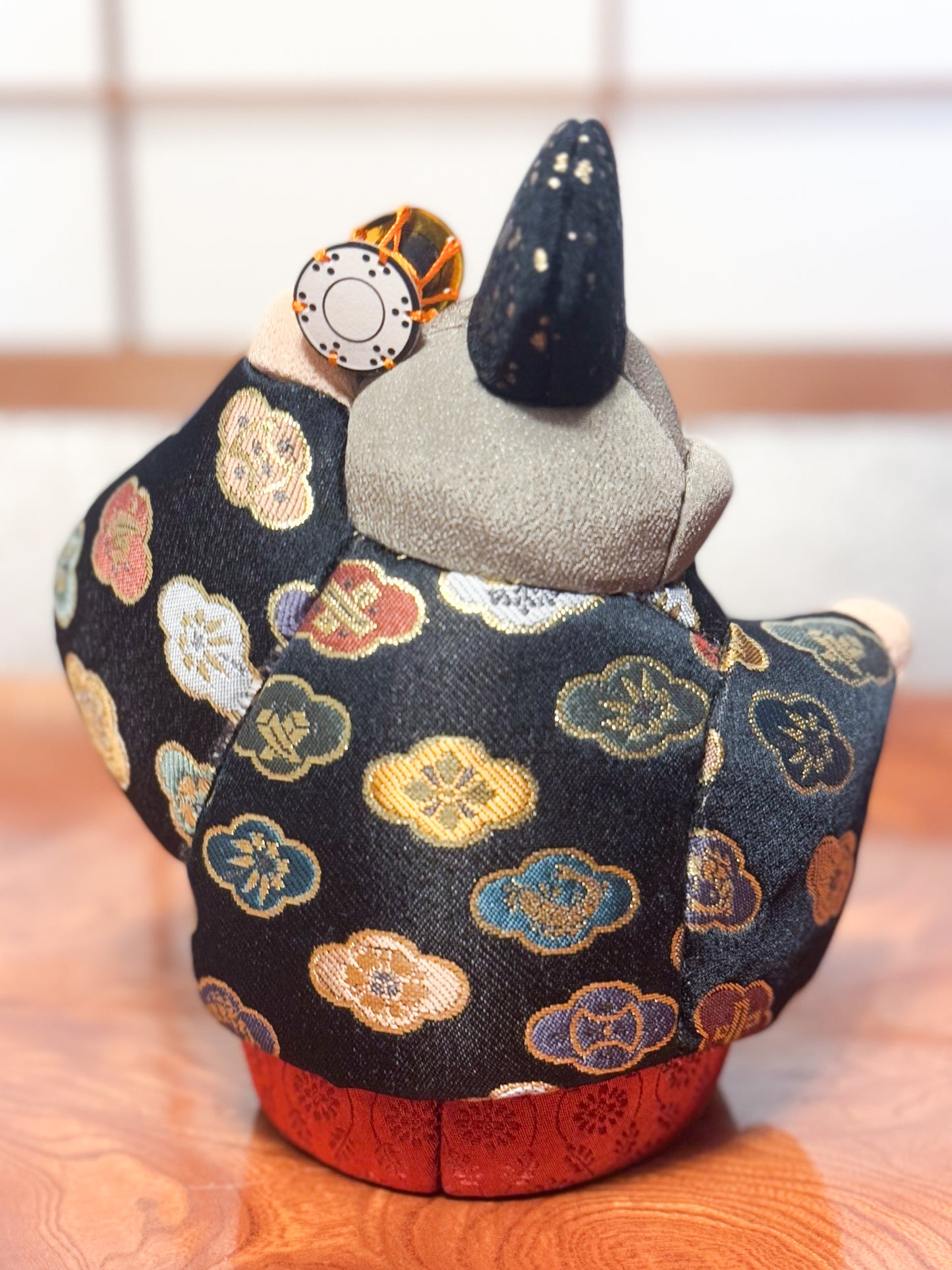 poupée japonaise kimekomi représentant un singe en habits traditionnels et portant un petit tambour, vu de dos