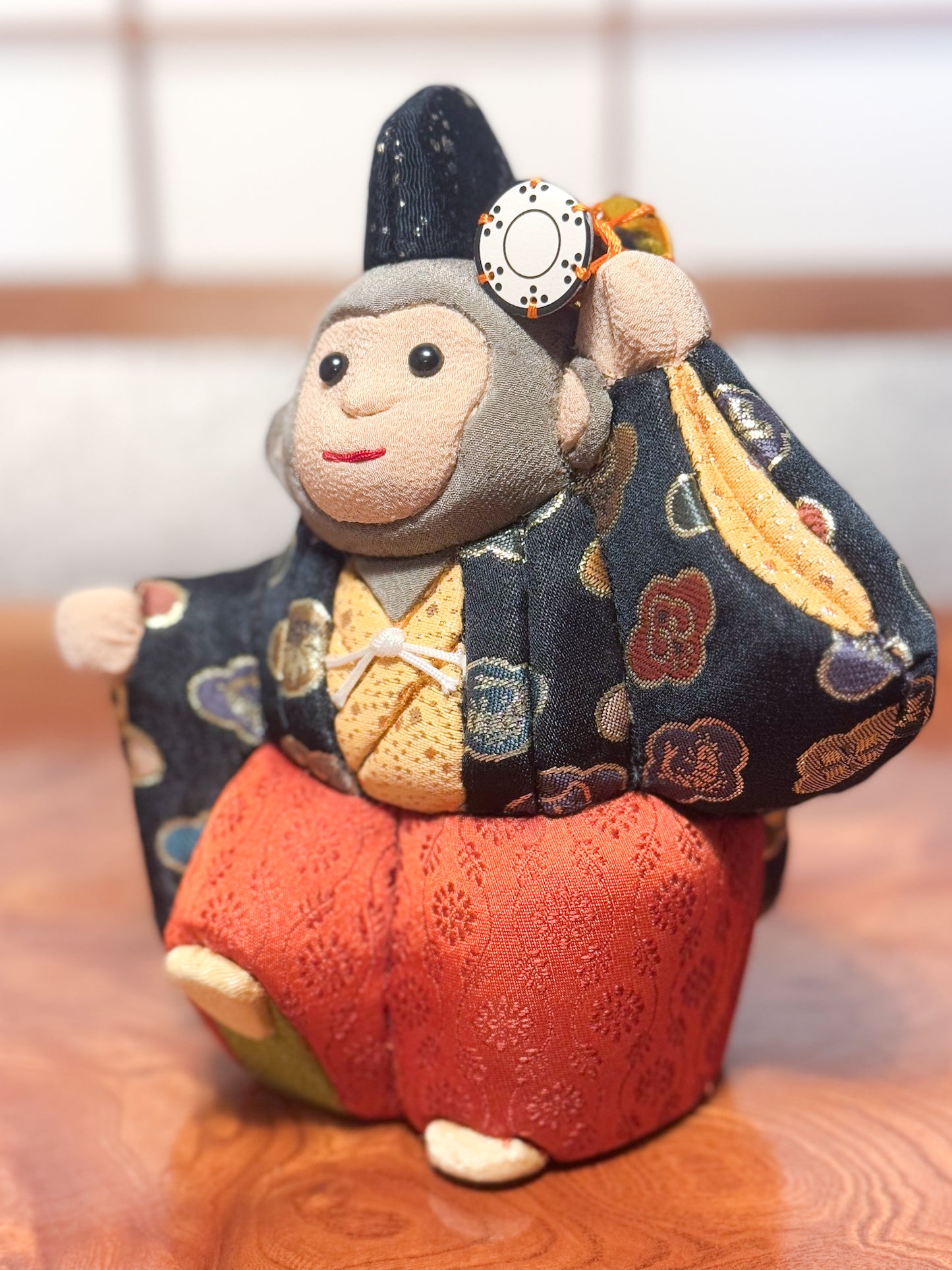 poupée japonaise kimekomi représentant un singe en habits traditionnels et portant un petit tambour, profil gauche