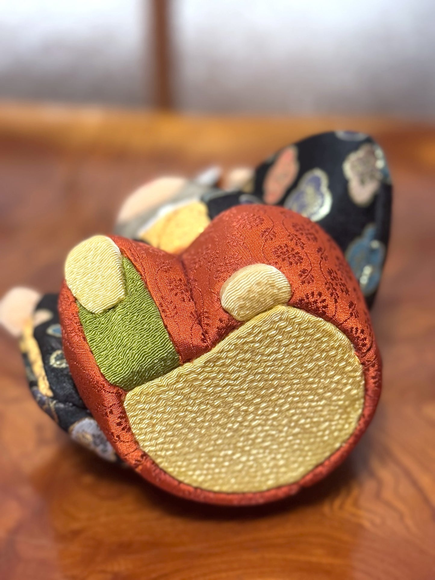 poupée japonaise kimekomi représentant un singe en habits traditionnels et portant un petit tambour, vu de dessous