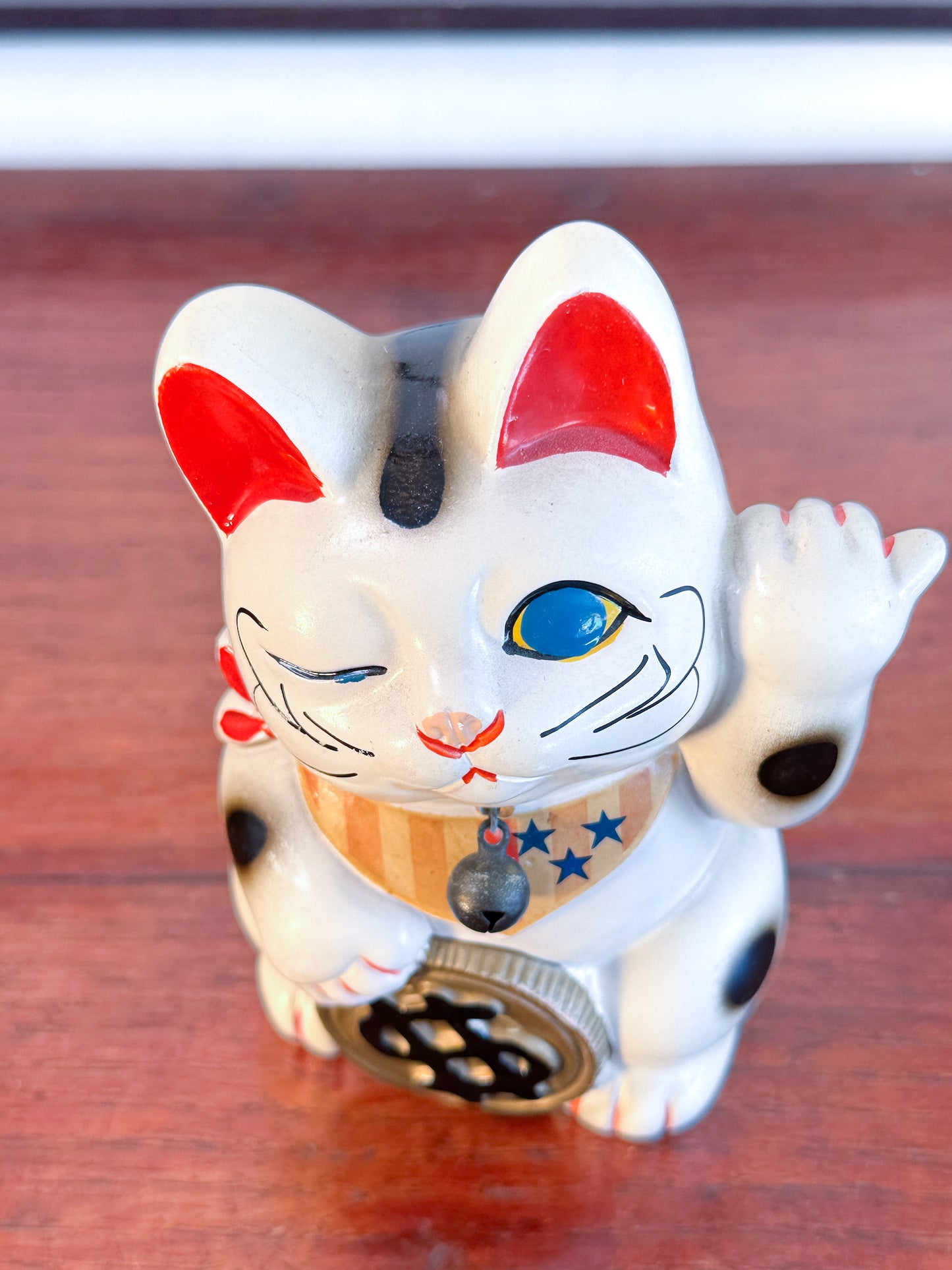 Maneki Neko blanc vintage avec clin d’œil, pièce dollar et motifs étoilés façon drapeau américain, dessus
