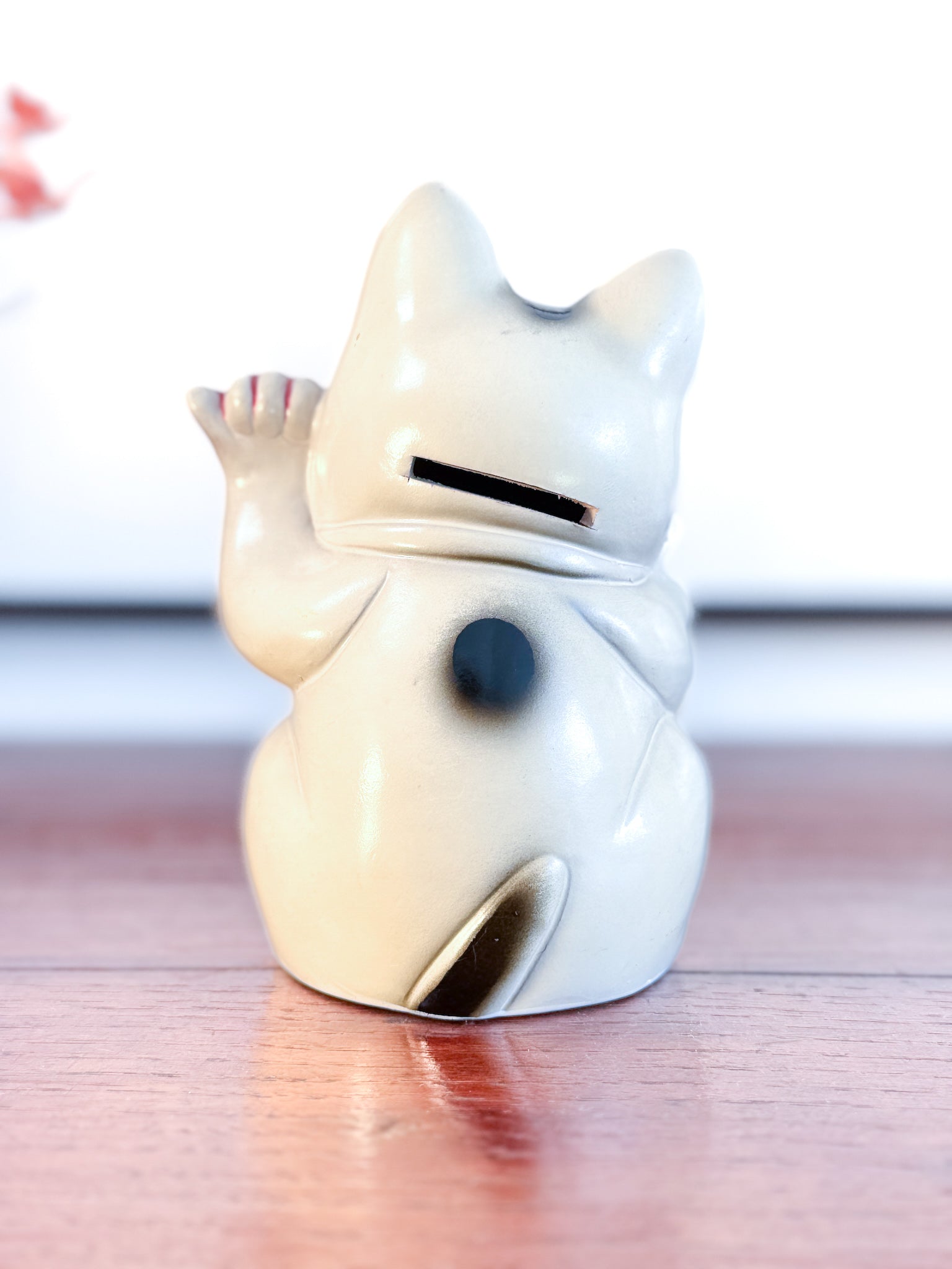 Maneki Neko blanc vintage avec clin d’œil, pièce dollar et motifs étoilés façon drapeau américain, vu de dos