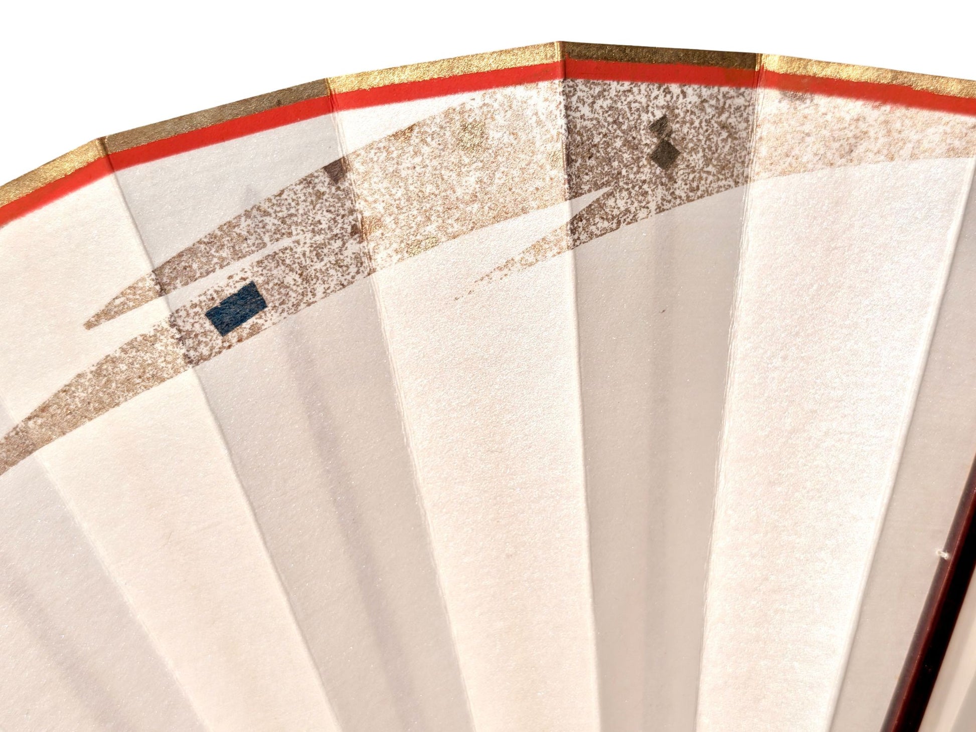 Eventail japonais nacré motif flamme pailleté d'or, monture en laque acajou, gros plan sur le motif