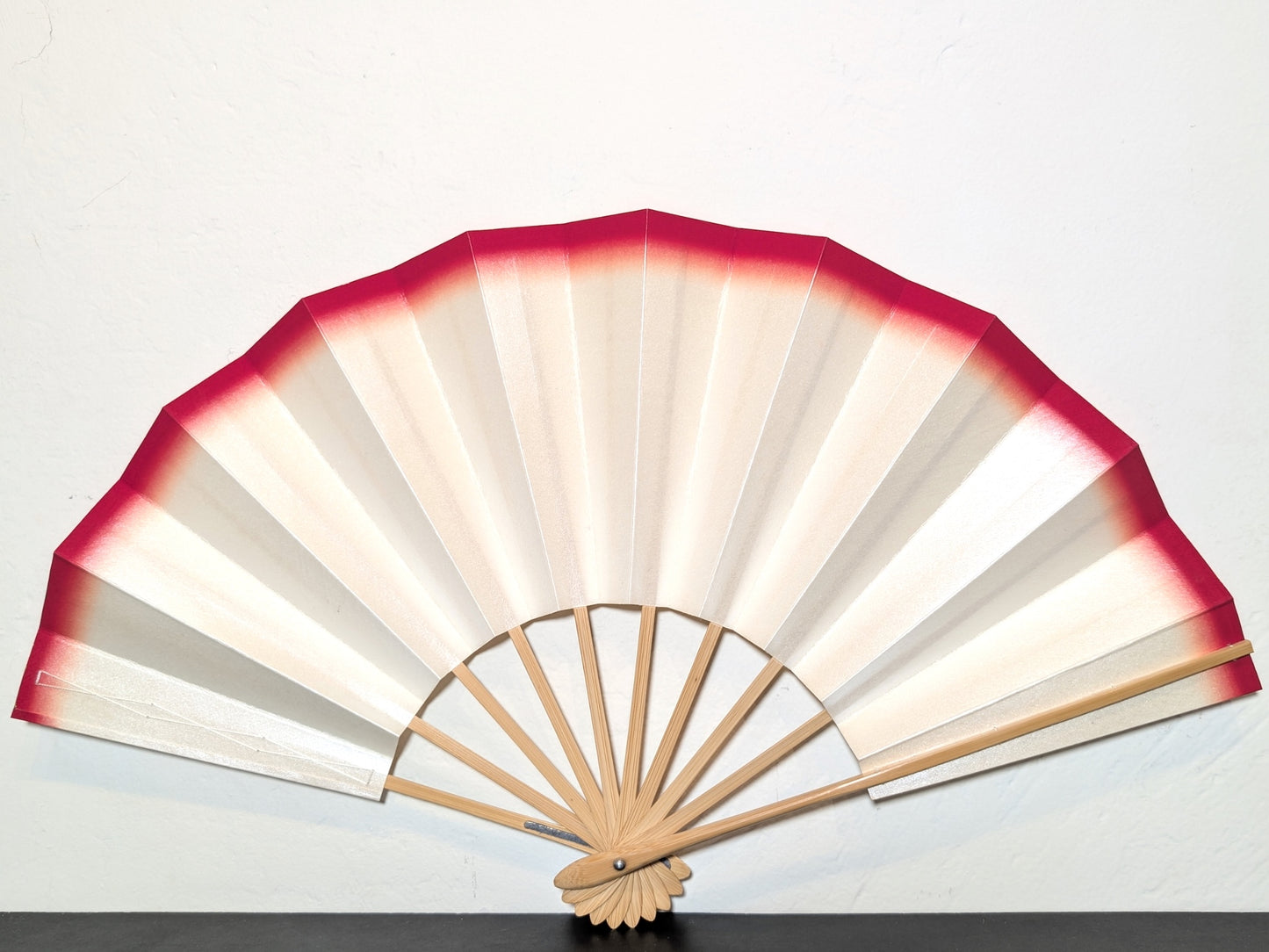Eventail traditionnel japonais de théâtre kabuki monté sur bambou. Couleur blanc micacé et filet rouge sur le bord.