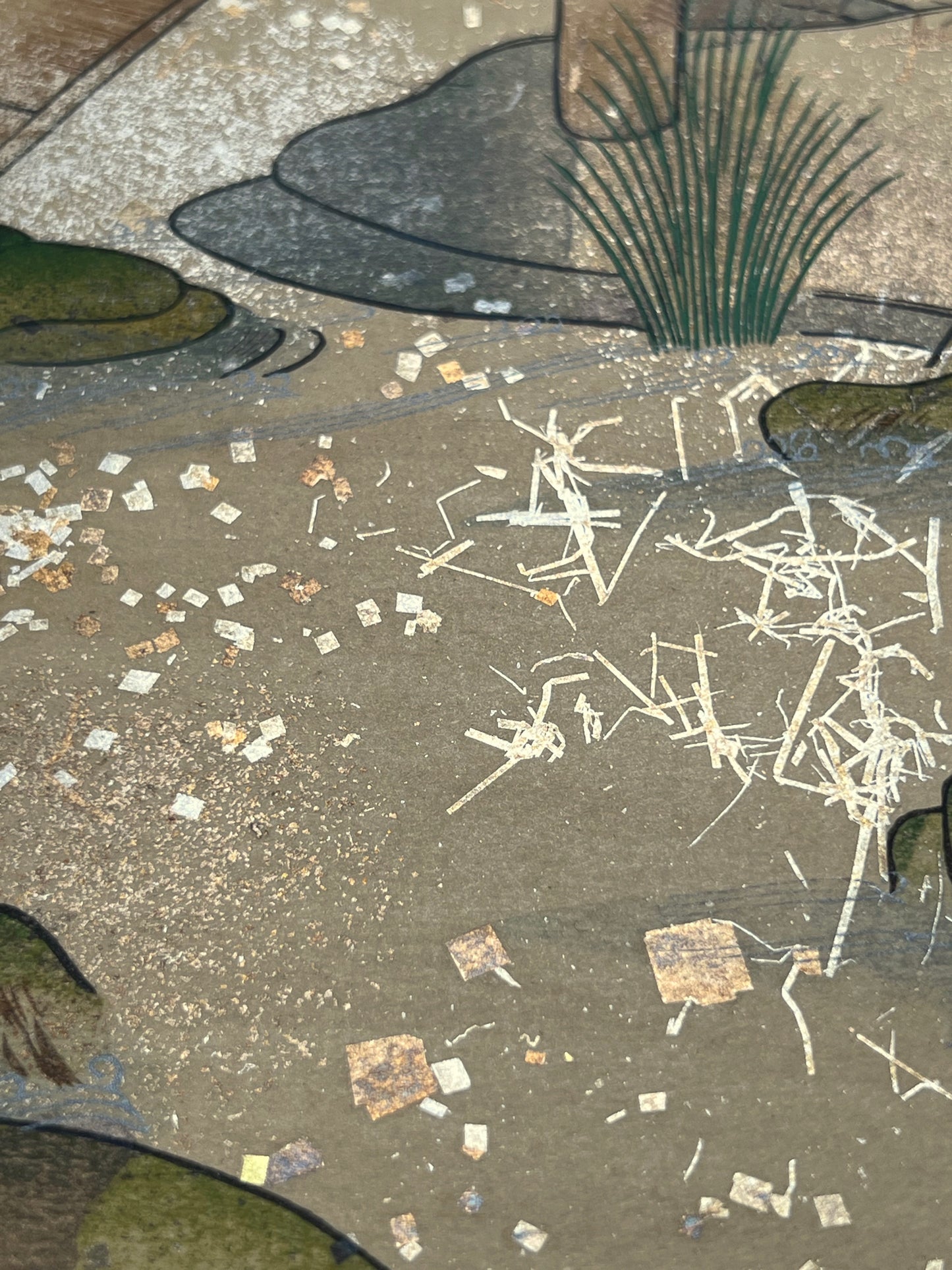 Estampe japonaise en forme d'éventail parsemée de fragments d'or et d'argent, gros plan sur l'eau de la rivière, herbes et rochers, fragments scintillants.