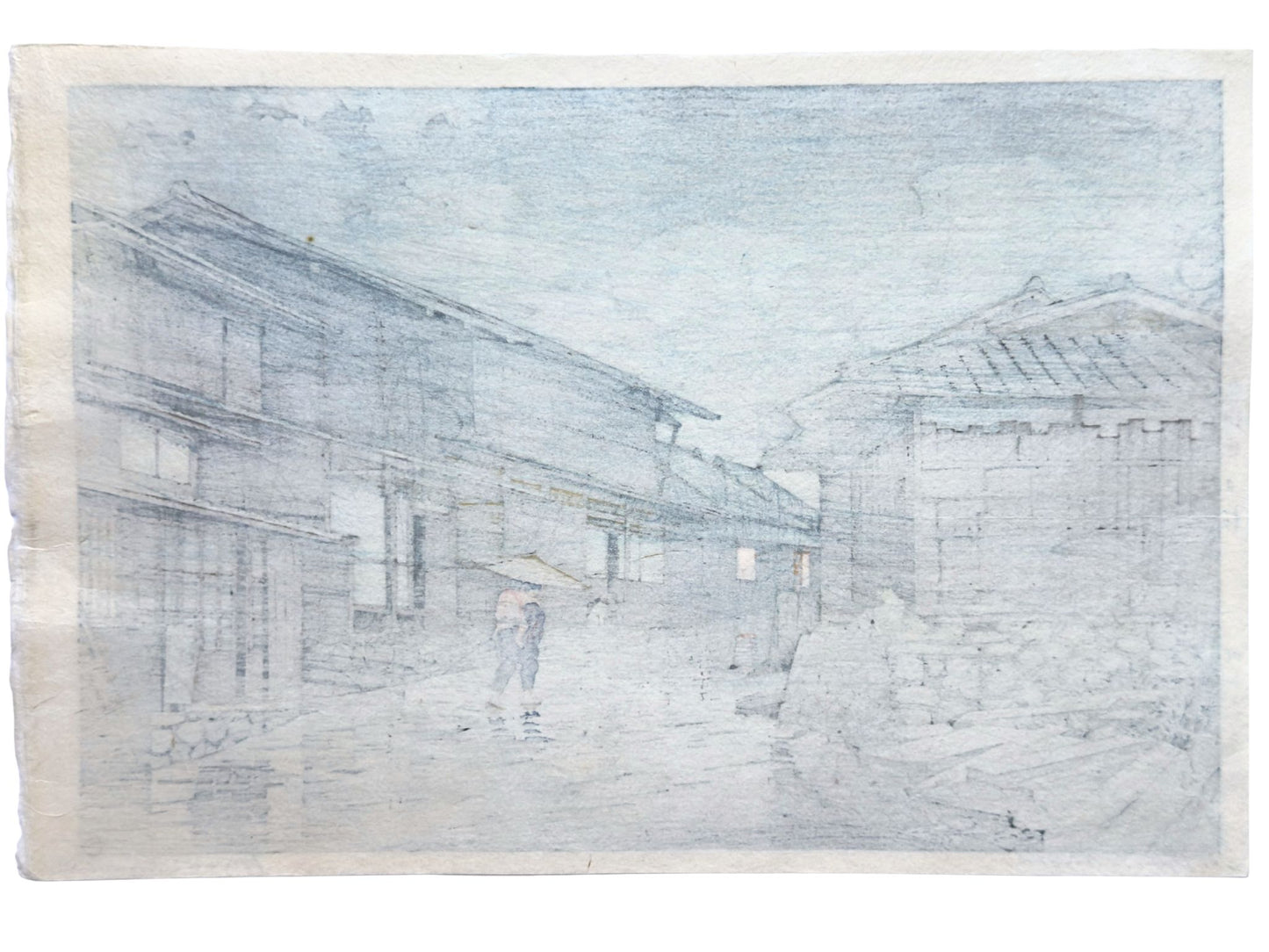 estampe japonaie de Kawase Hasui, femme portant un enfant sur son dos, sous un parapluie, marchant dans une rue d'un village, une nuit pluvieuse, le verso de l'estampe