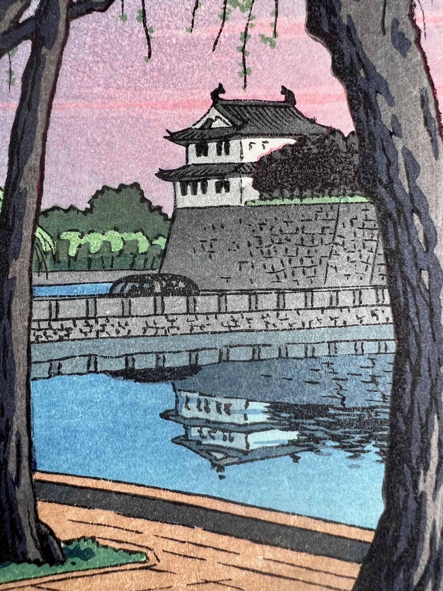 estampe japonaise lumière rose du soir sur le palais impérial de Tokyo, reflet du chateau dans la rivière