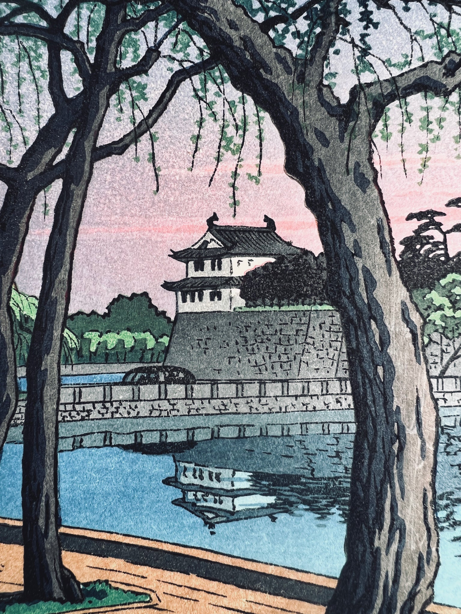 estampe japonaise lumière rose du soir sur le palais impérial de Tokyo, le chateau entre les arbres