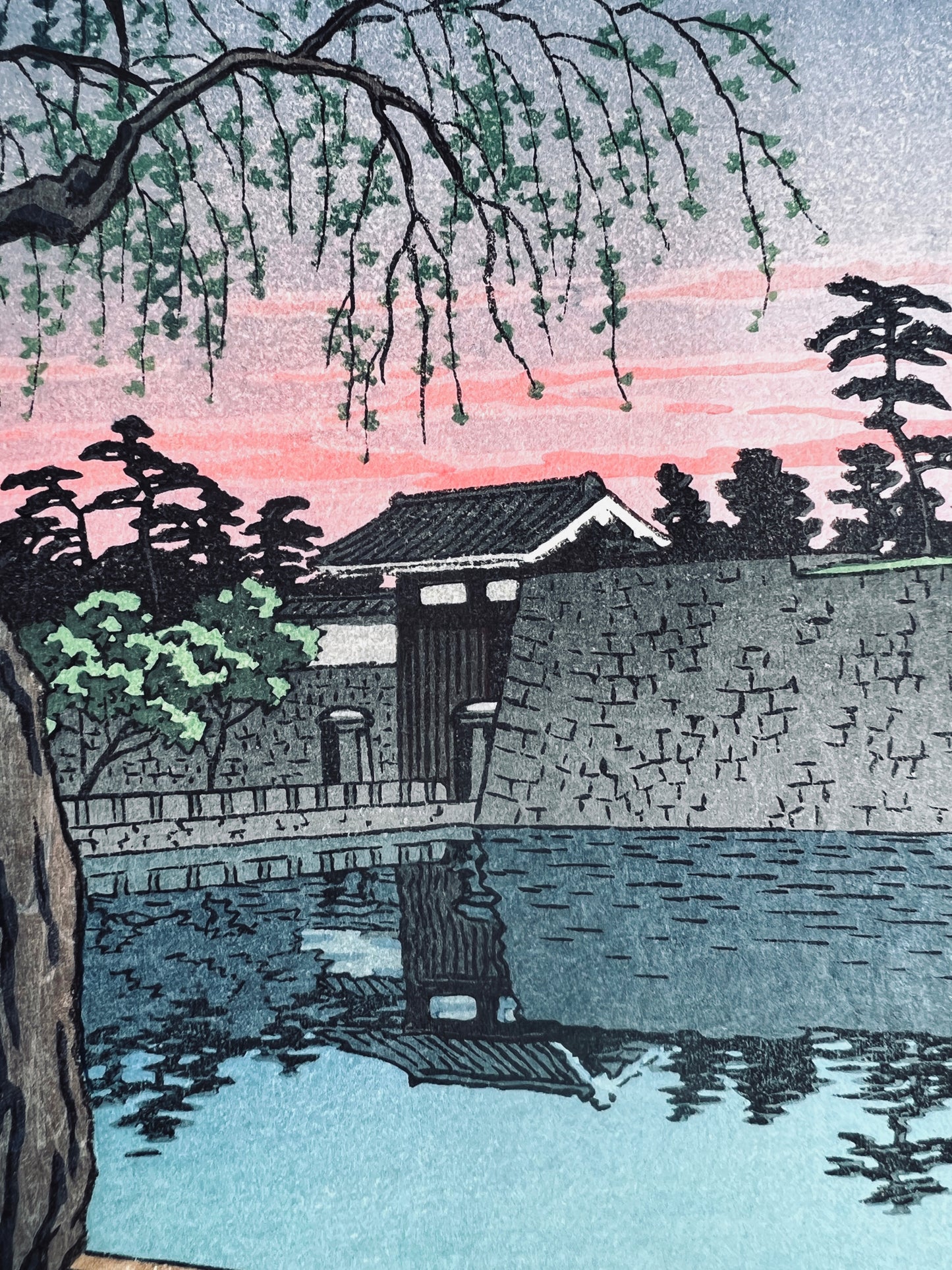 estampe japonaise lumière rose du soir sur le palais impérial de Tokyo, reflet de la porte d'enceinte dans la rivière