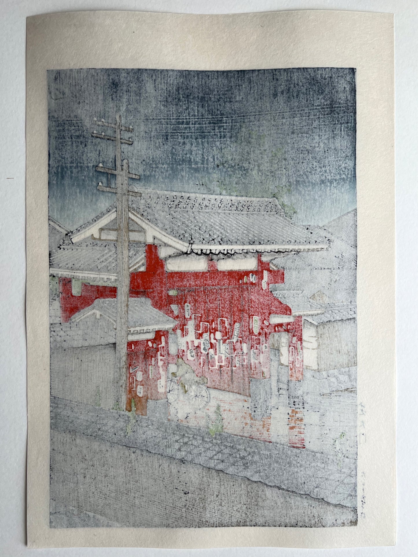 estampe japonaise un personnage à vélo franchit la grande porte rouge d'un temple sous la pluie à Tokyo, dos de l'estampe