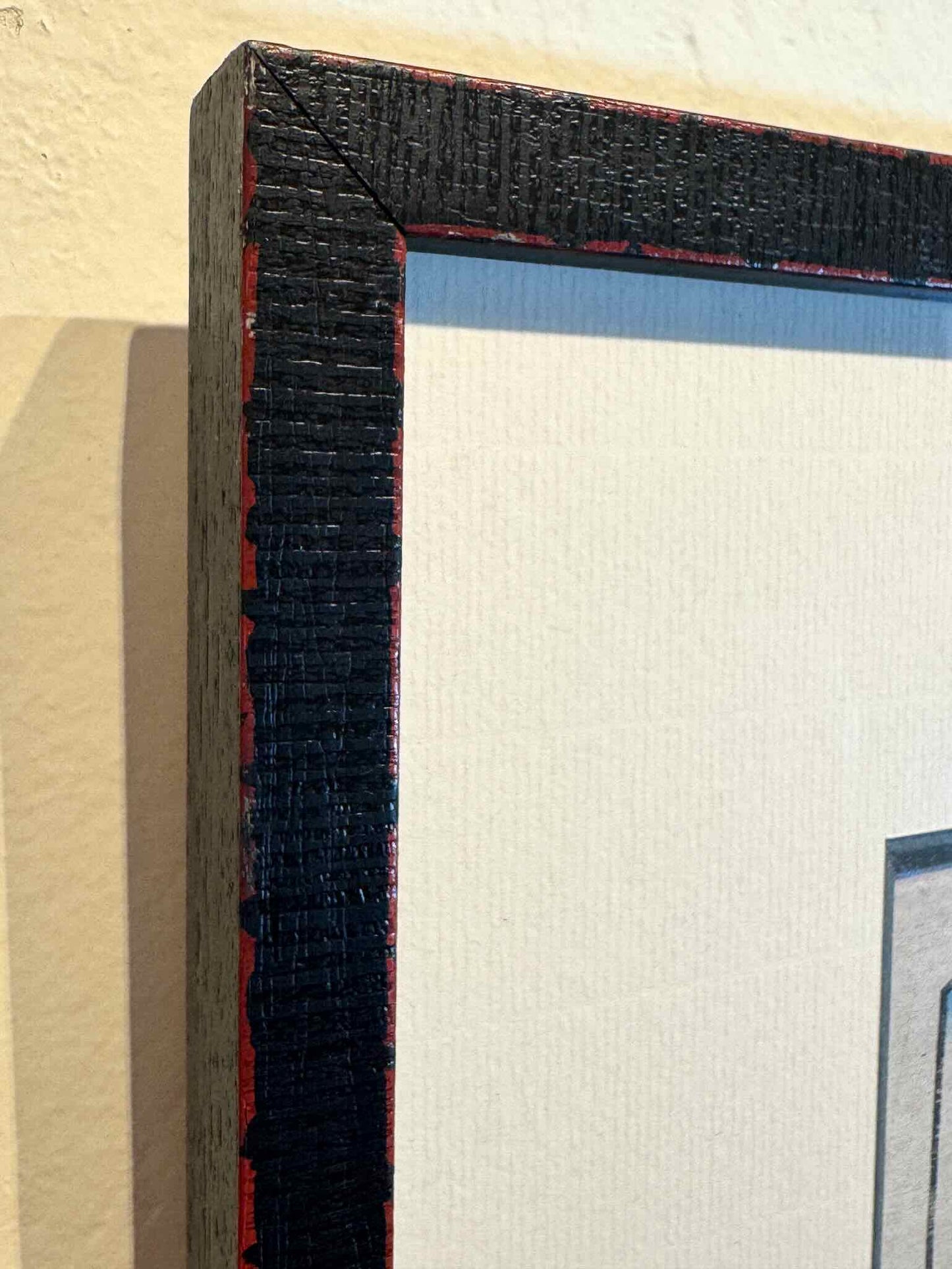 gros plan sur l'angle du cadre noir strié avec filet rouge