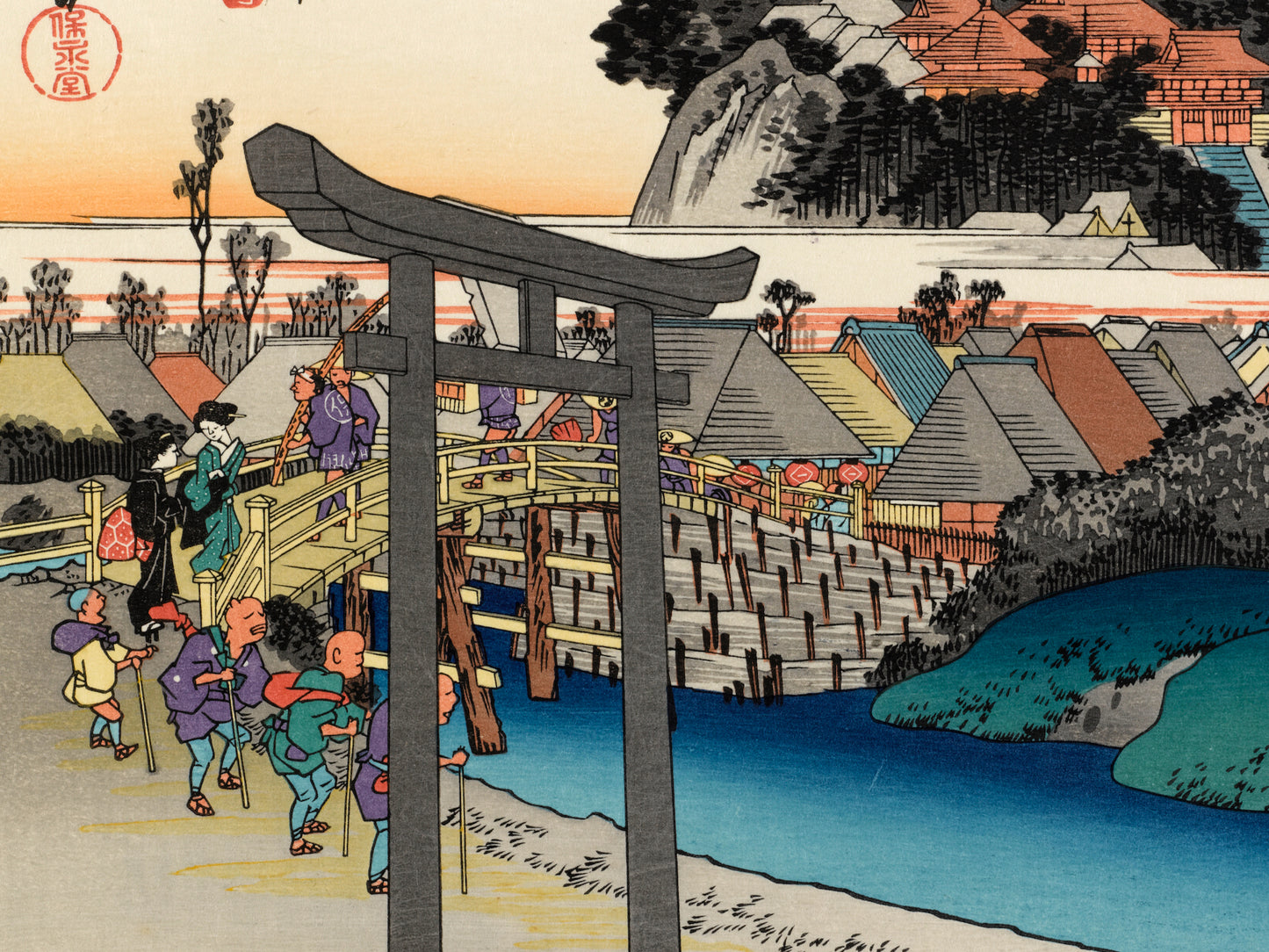 estampe japonaise de Hiroshige, la station Fujisawa du Tokaido avec un tori d'un sanctuaire shinto en premier plan, des personnes traversant le pont dont un groupe d'aveugles