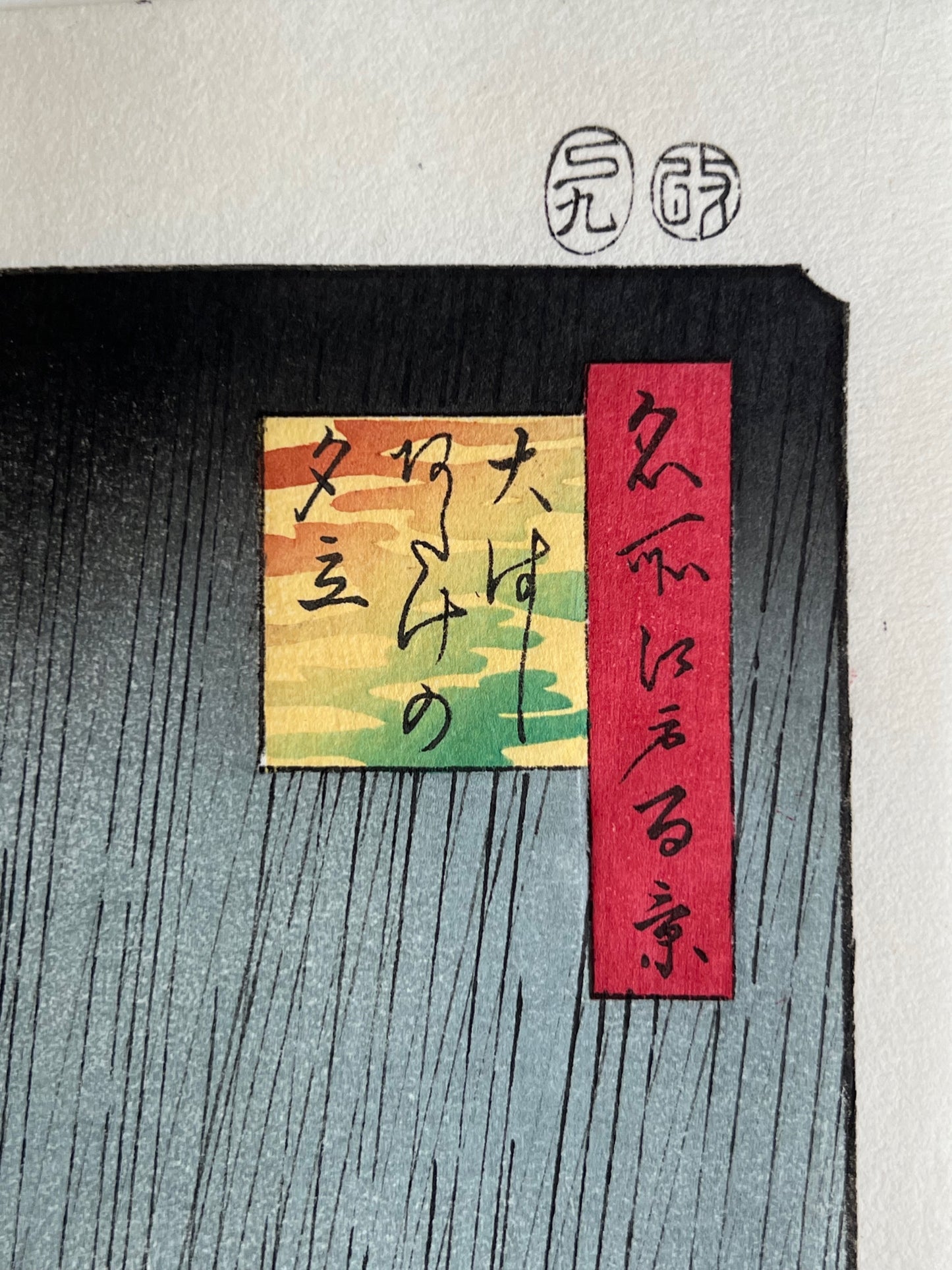 Estampe Japonaise d’Utagawa Hiroshige représentant une averse sur le pont Ōhashi et la rivière Sumida, célèbre pour la copie de Van Gogh, détail du cartouche de la série et du titre