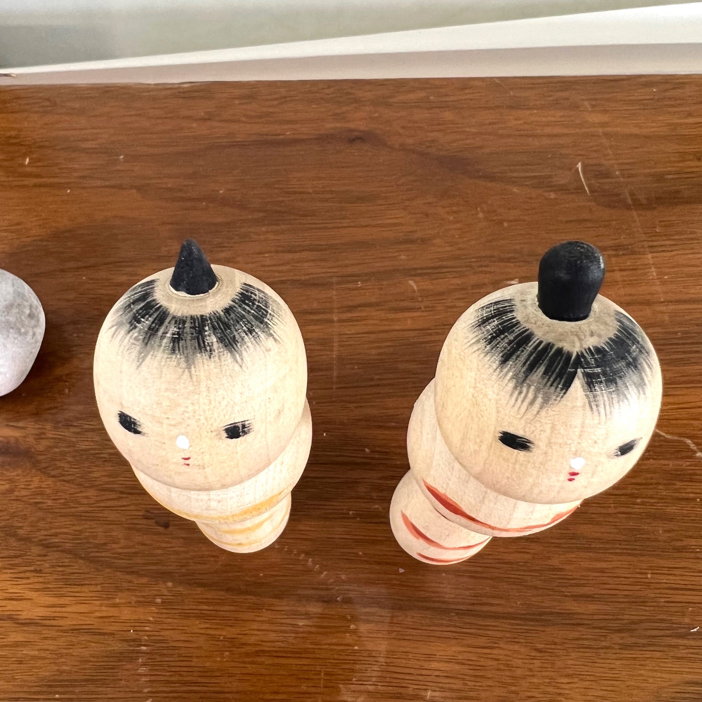 kokeshi, poupée japonaise en bois, couple avec ceinture rouge pour la femme et jaune pour l'homme, vu de dessus