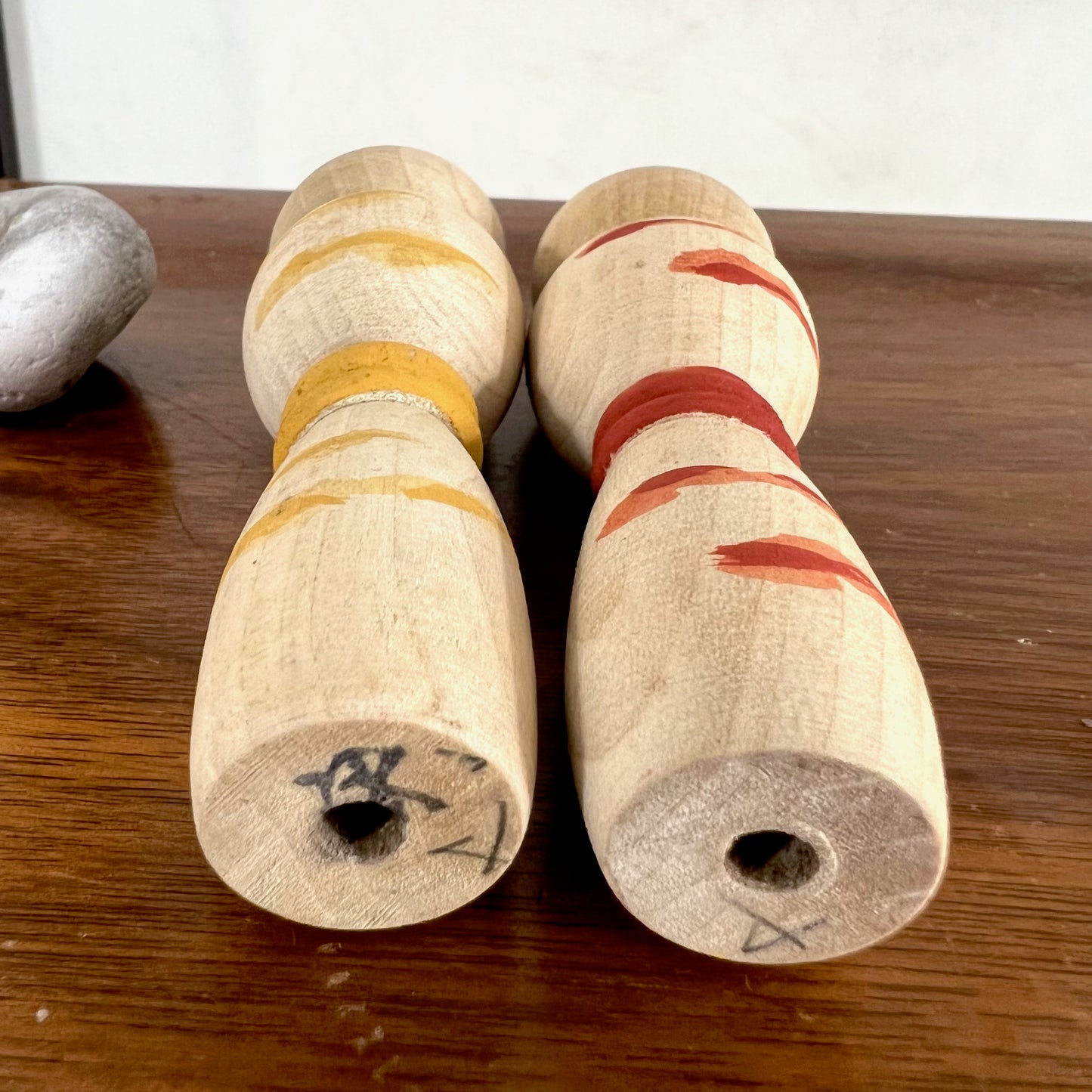 kokeshi, poupée japonaise en bois, couple avec ceinture rouge pour la femme et jaune pour l'homme, signature de l'artisan