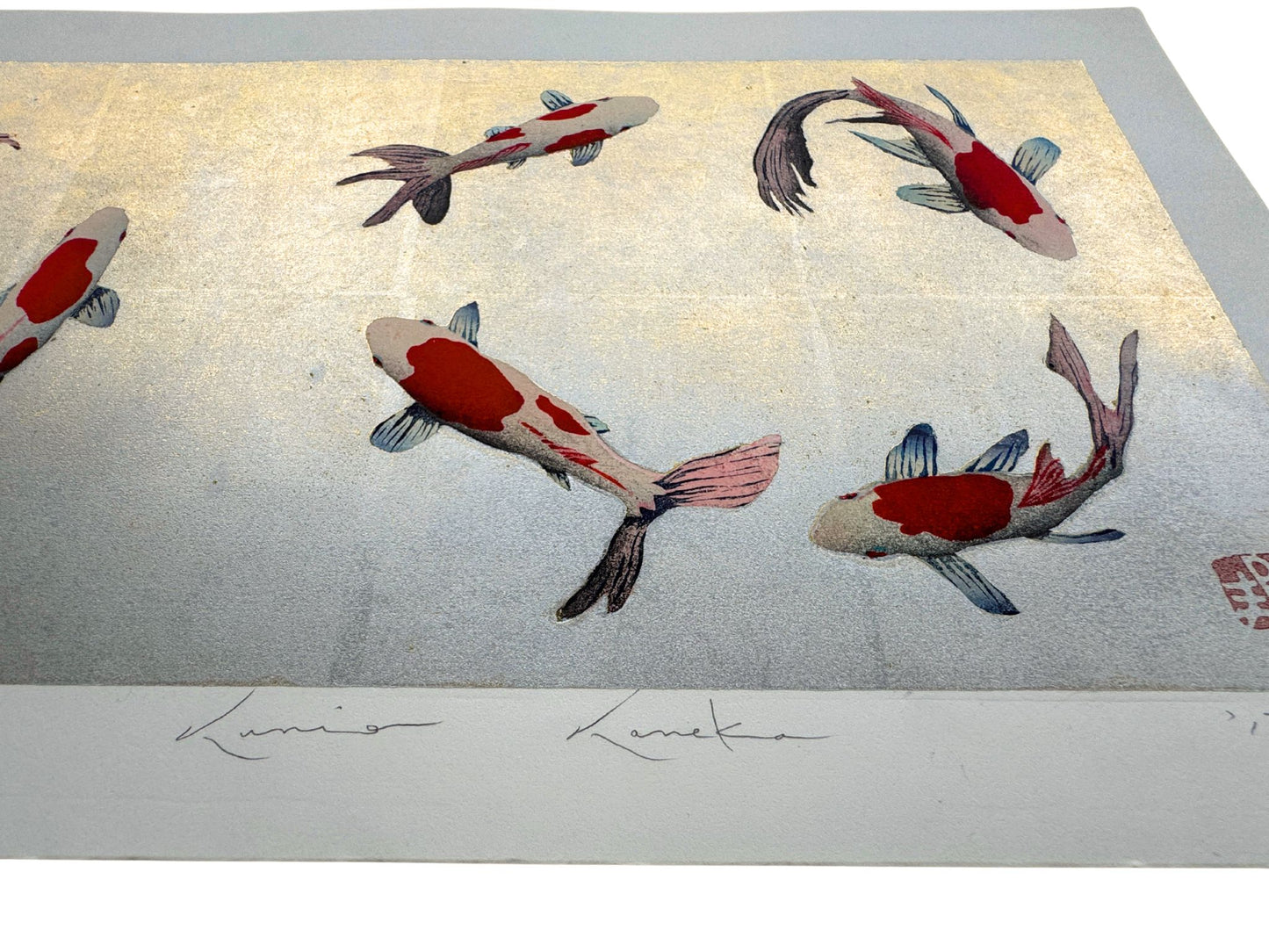 Estampe japonaise de Kunio Kaneko représentant des carpes Koï sur fond doré et argenté, vue de profil des reflets brillants