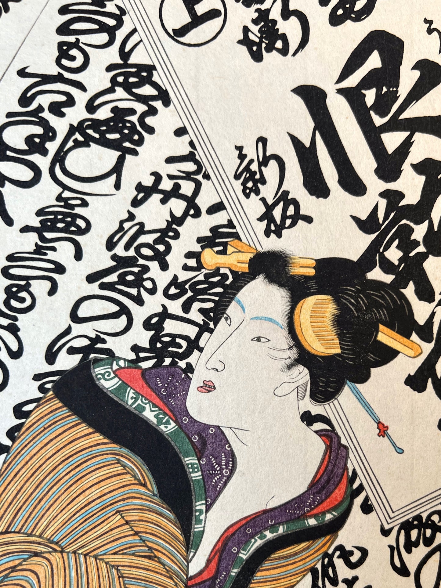 estampe japonaise de Kunisada, une mère tenant son bébé dans les bras sur fond de calligraphie japonaise, gros plan visage femme