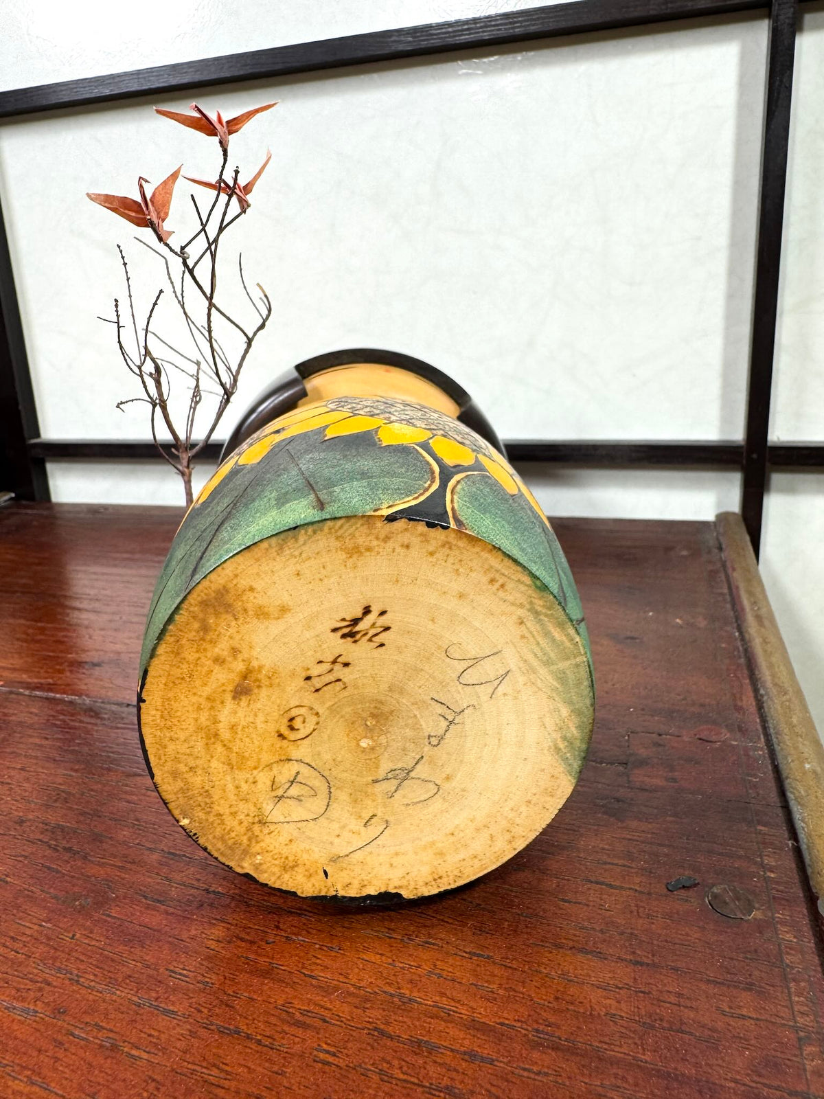 Kokeshi vintage japonaise de Yuji Kawase ornée de grands tournesols jaunes gravés et peints sur fond vert et noir, la signature au dessous