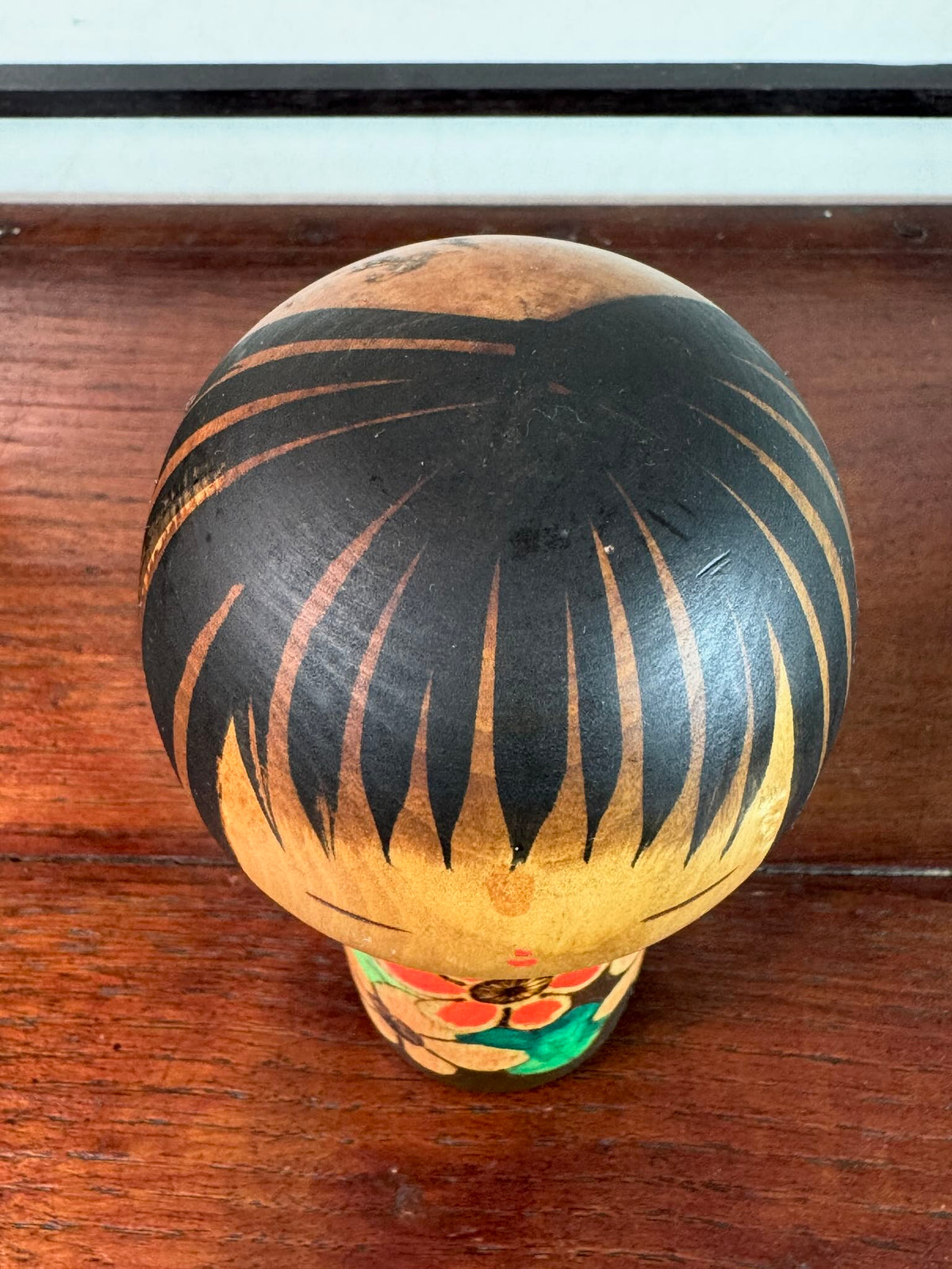 Kokeshi Yuji Kawase brune aux fleurs rouges et roses, le dessus de la tête
