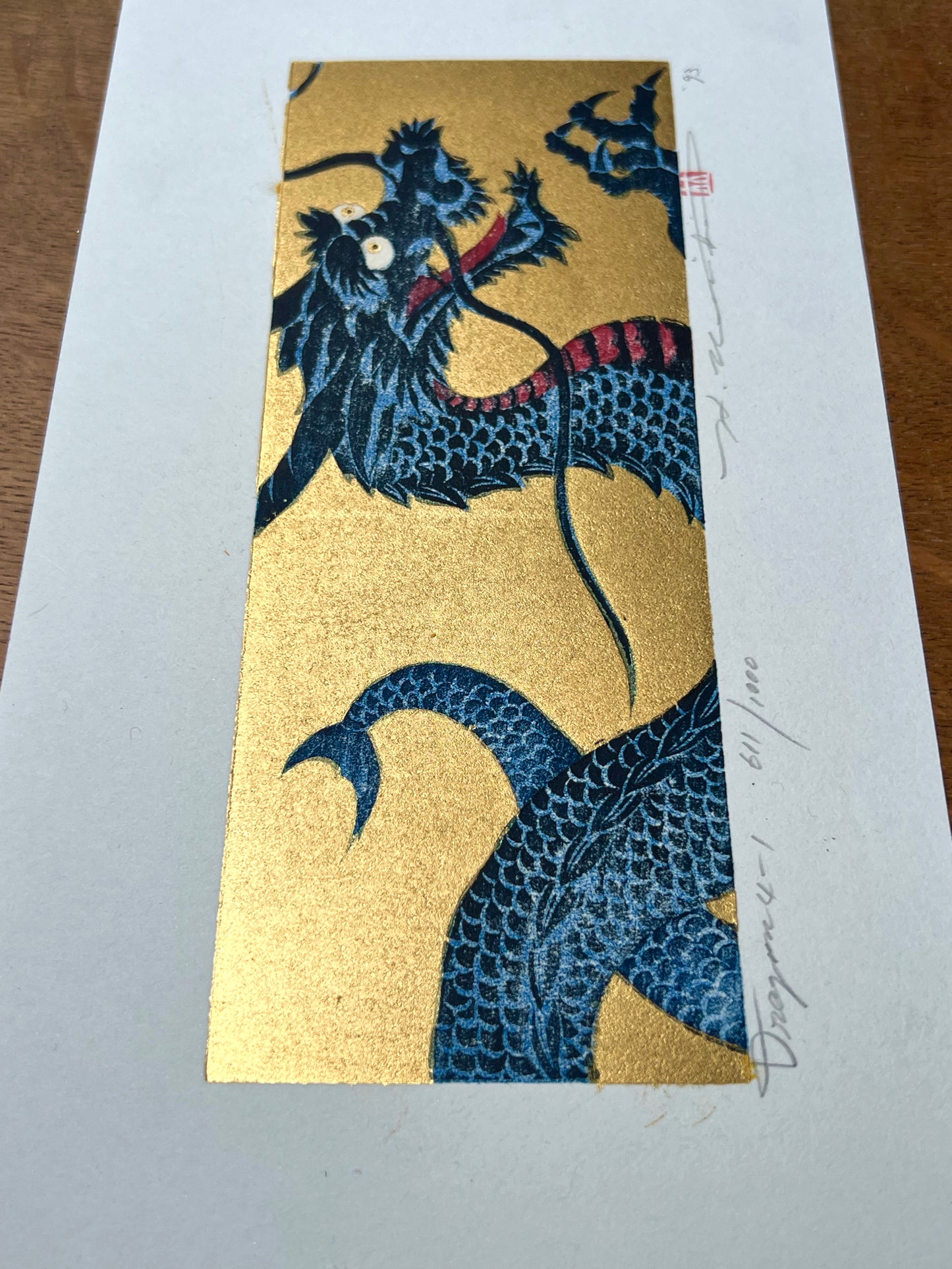 estampe japonaise dragon bleu gueule ouverte sur fond or, vue plongeante profil queue or scintillant