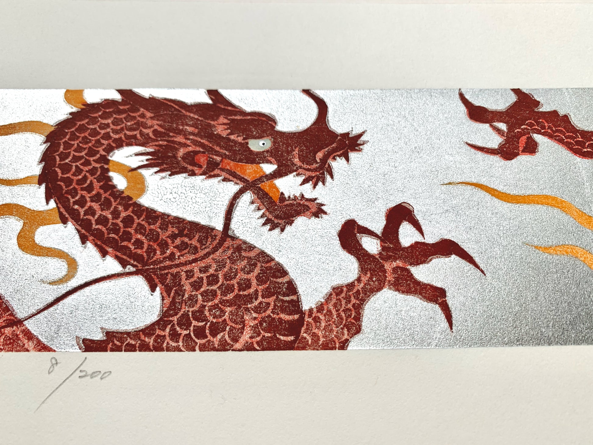 estampe japonaise de Namiki Hajime, deux dragons rouges sur fond argenté se font face, l'un gueule ouverte, l'autre gueule fermée, gros plan et numérotation de l'artiste