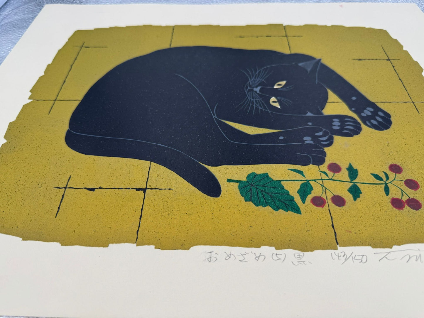Estampe japonaise de Nishida représentant un chat noir étendu au réveil sur fond doré, vue de profil