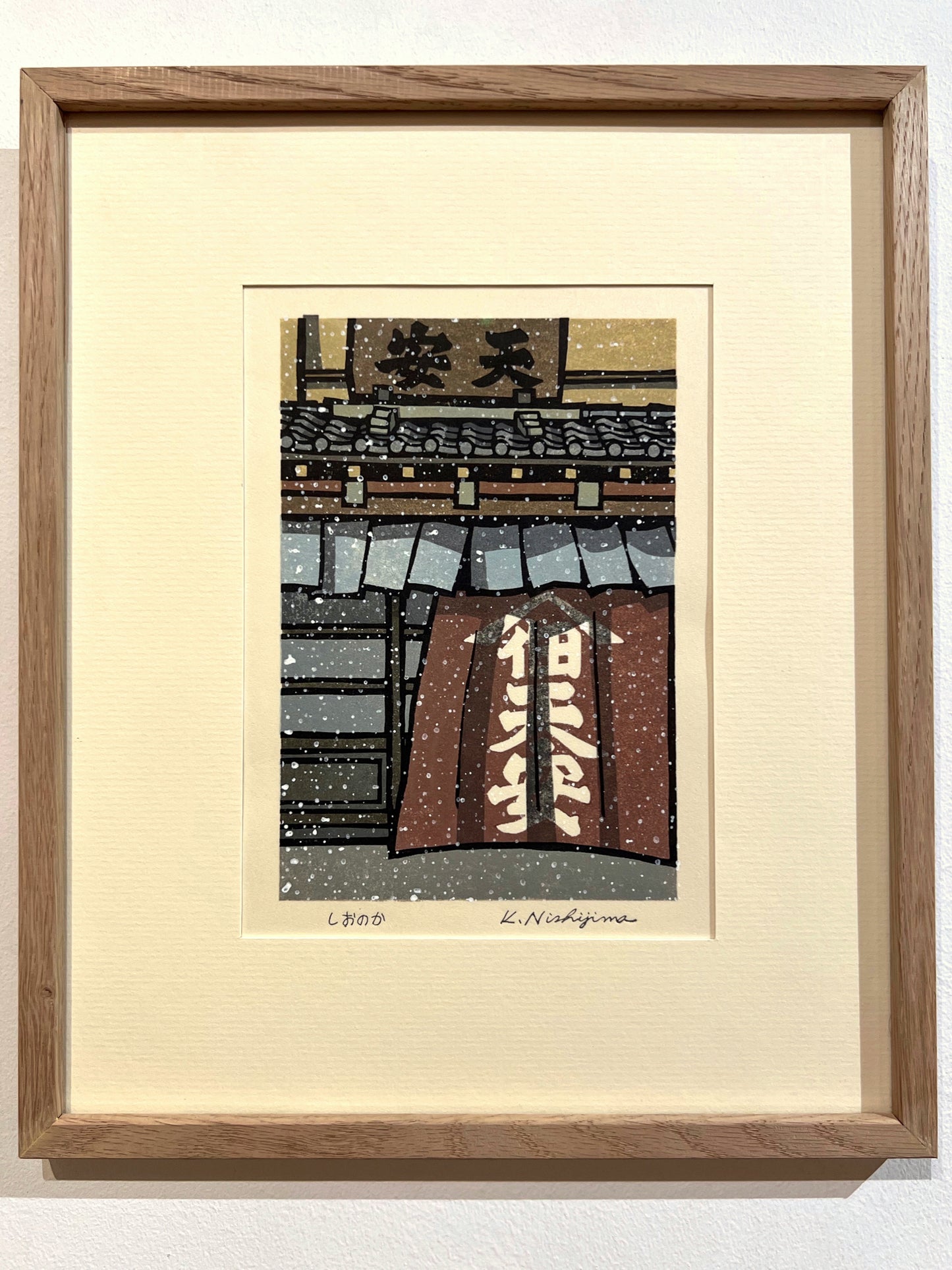 estampe japonaise contemporaine de de Nishijima, la neige tombe devant une facade d'une maison en bois avec noren calligraphié, à Kyoto. Exemple d'encadrement avec un cadre en plat 10 chêne