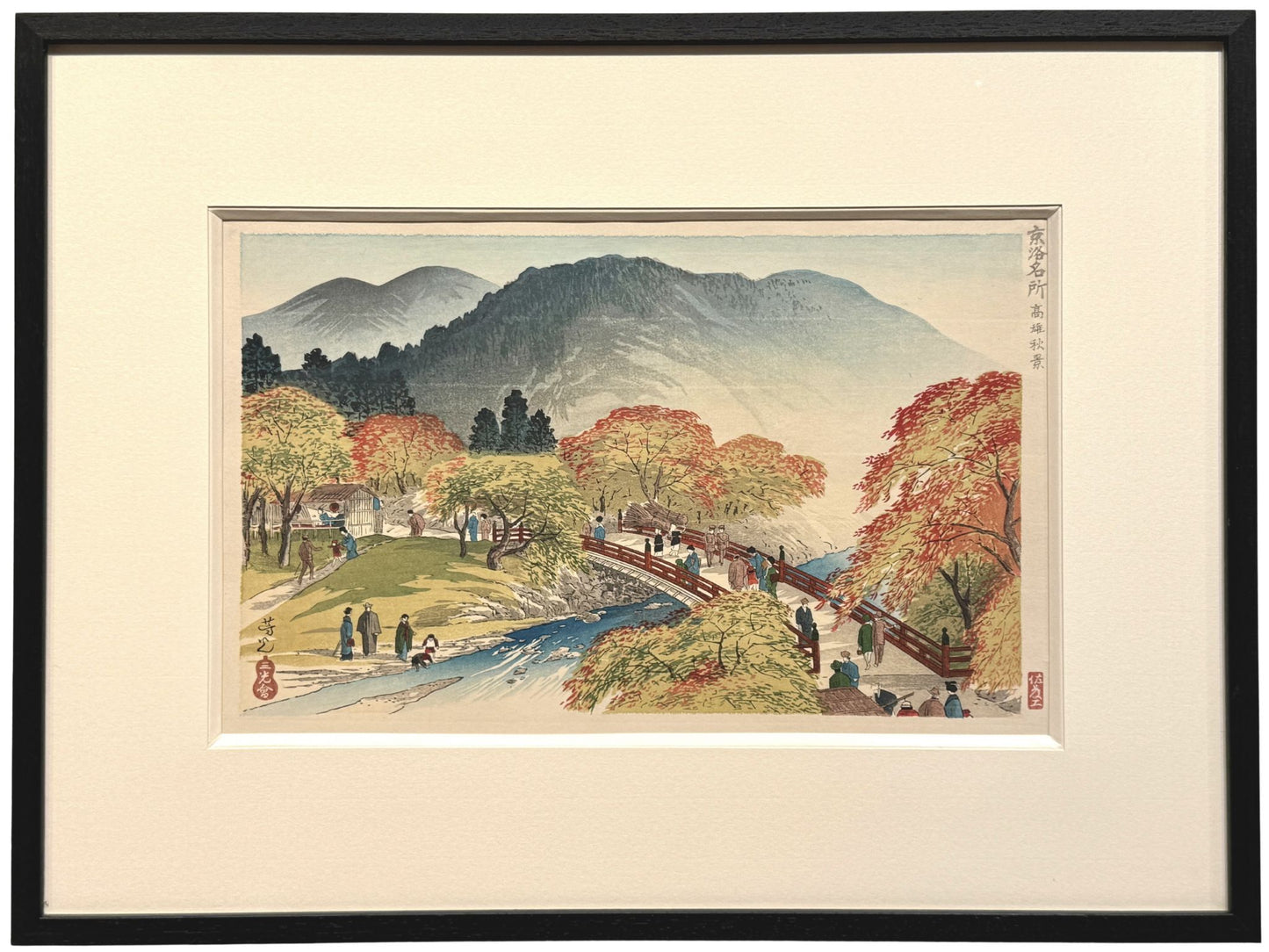 estampe japonaise encadrée de Nomura Yoshimitsu représentant un paysage d'automne avec érables rouges, pont, rivière et promeneurs. Avec cadre noir